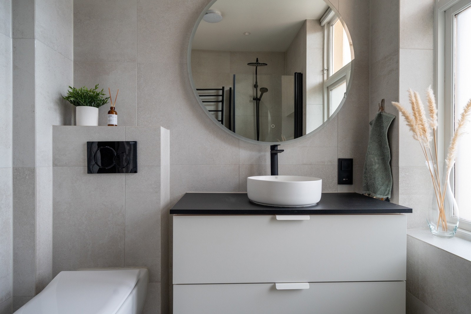 Badet har en eksklusiv look med moderne fliser, vegghengt toalett, varmekabler og speil med lys. Galleribilde