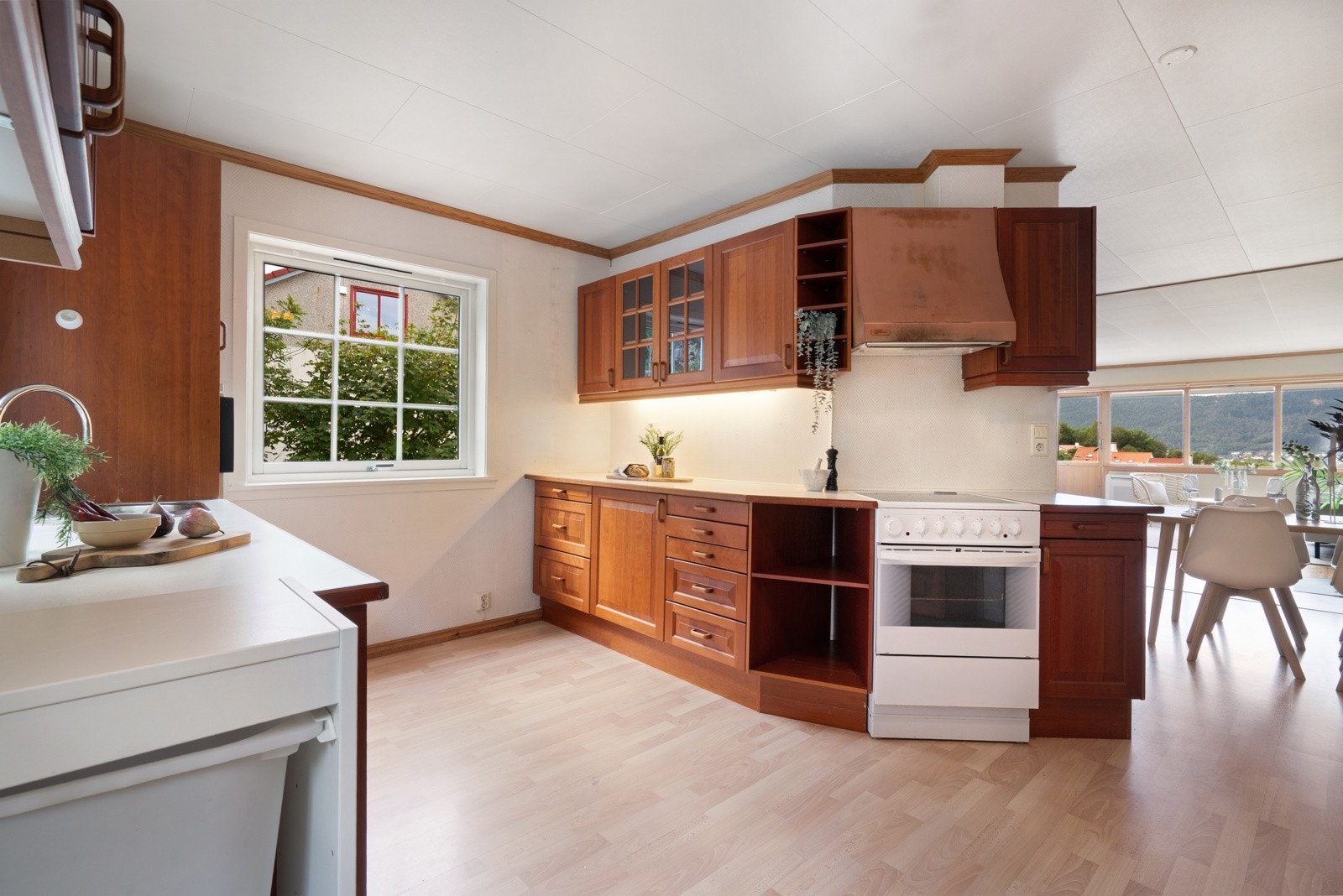 Kjøkkenet har innredning av kirsebær beiset fyllingsfronter. Laminat benkeplate i lys farge Galleribilde