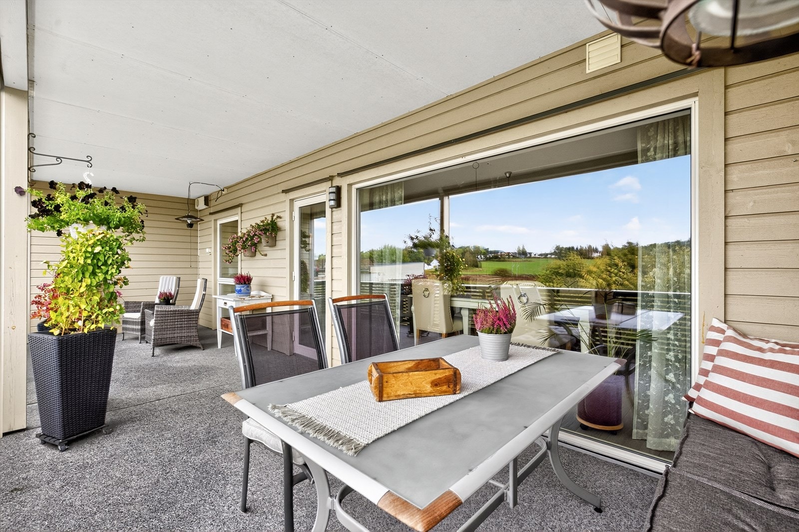 Verandaen er lun og fin med rekkverk og tette levegger mot naboer for skjerming. Galleribilde