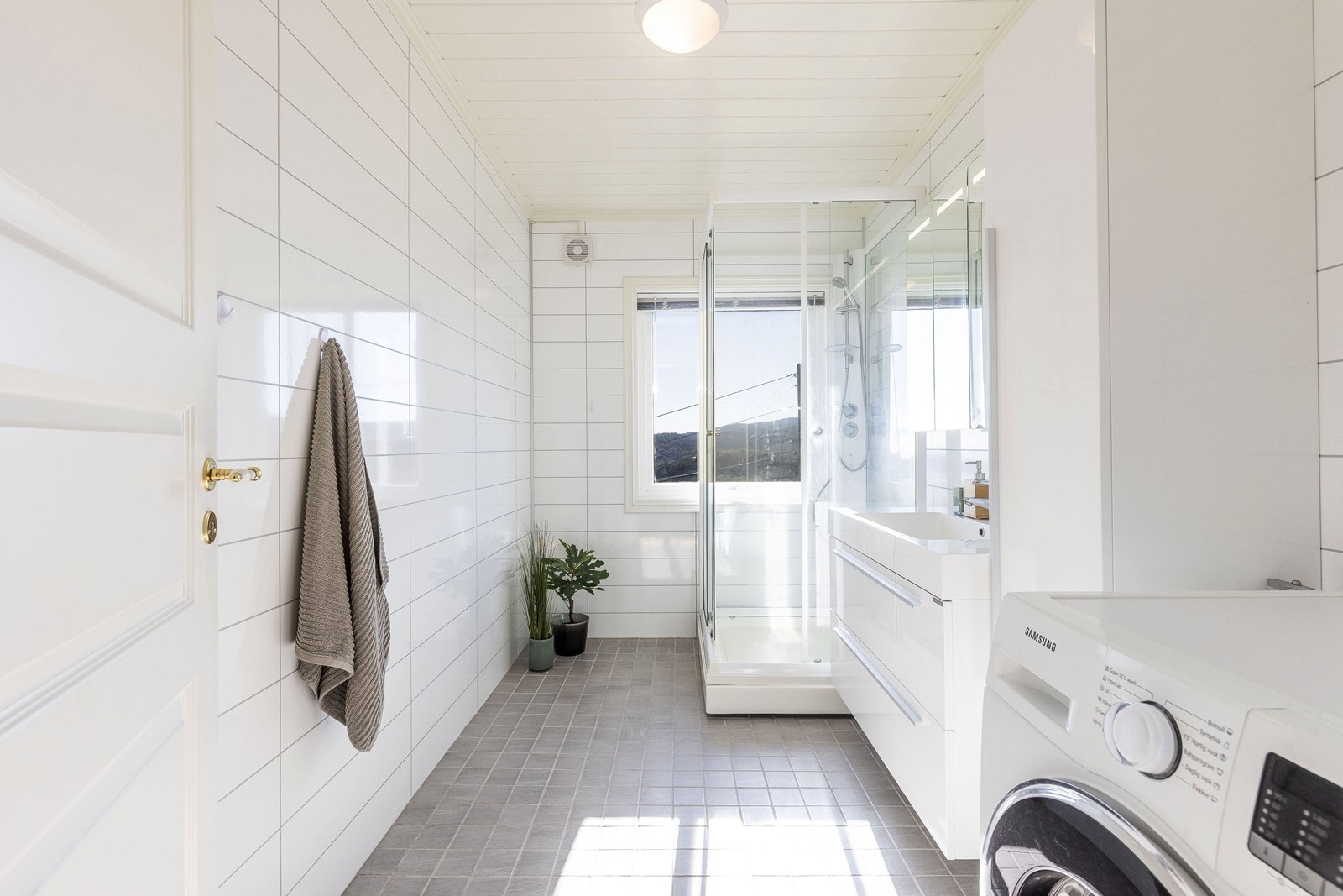 Badet er lyst og romslig med flislagt gulv og baderomsplater Galleribilde