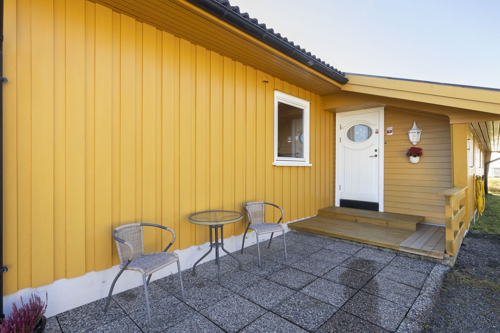 Fra gårdsplassen er det adkomst til et åpent inngangsparti med steinlagt dekke og liten sittegruppe Galleribilde