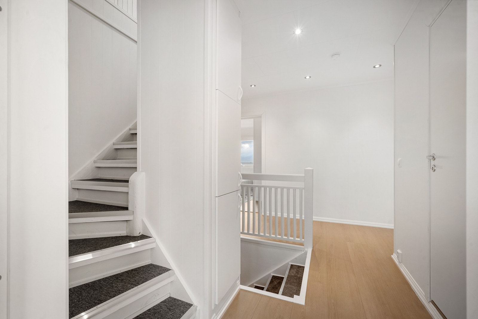 Innebygde skap i vegg mellom trappene for smart oppbevaring Galleribilde