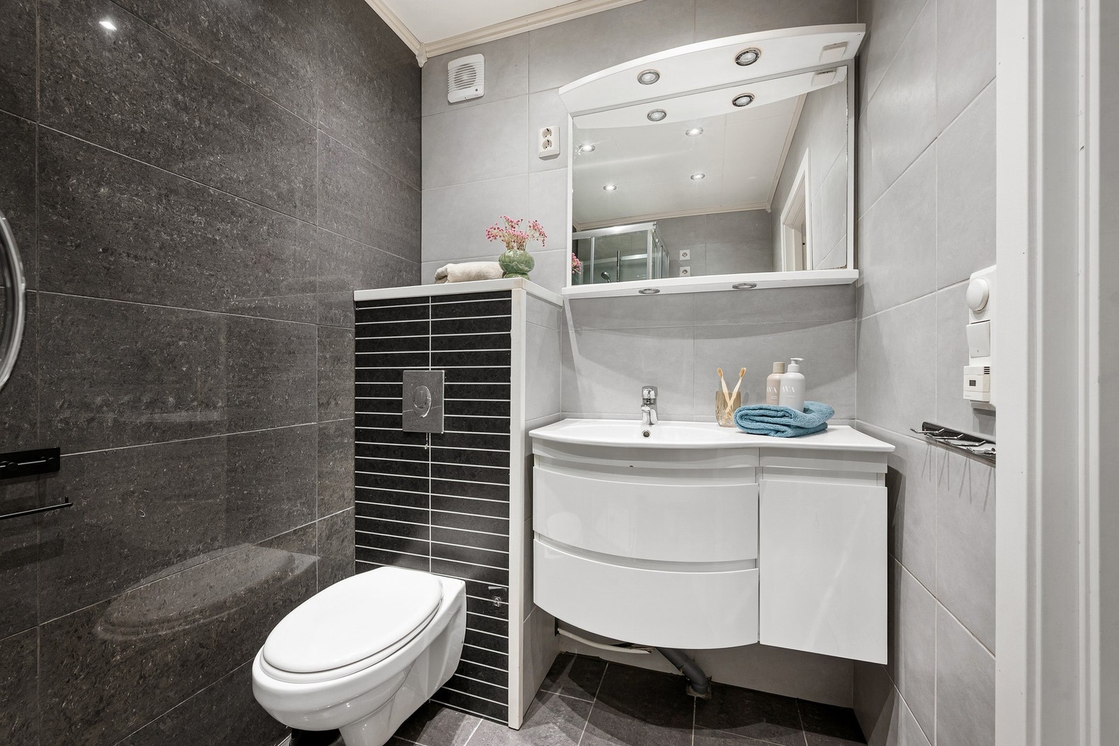 Flislagt bad med vegghengt servantinnredning og toalett Galleribilde