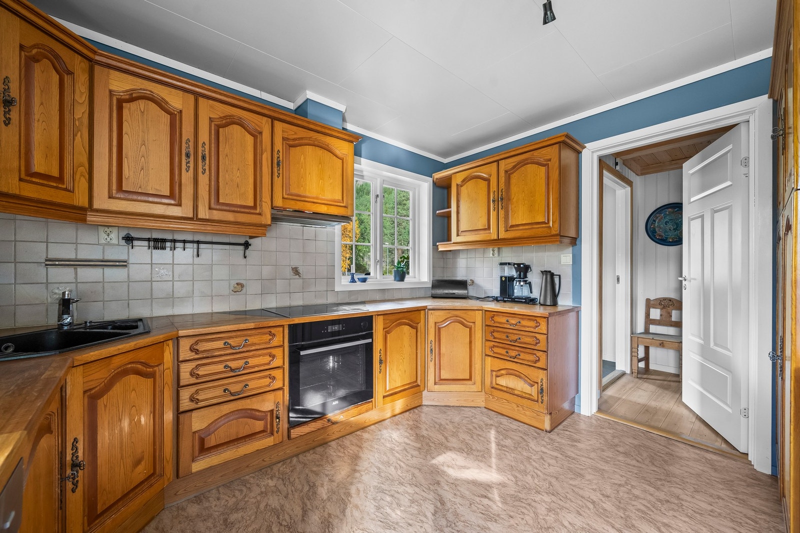 Kjøkken med benkeplater av heltre. Integrerte hvitevarer. En praktisk og koselig arbeidsplass med rom for spisebord og hyggelige måltider i hverdagen. Galleribilde