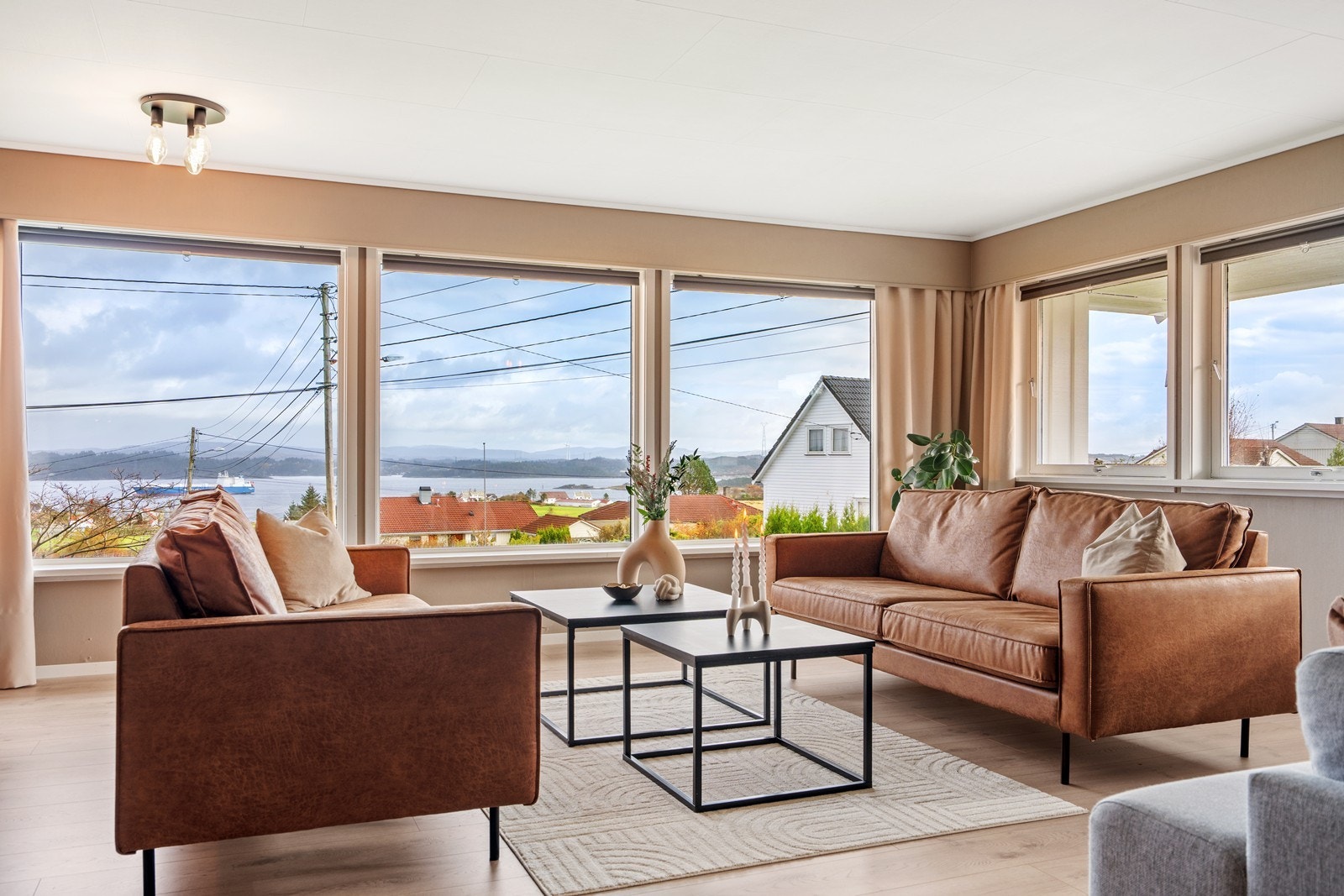 Boligen har en lys og flott stue i 1. etasje med fantastisk sjøutsikt Galleribilde