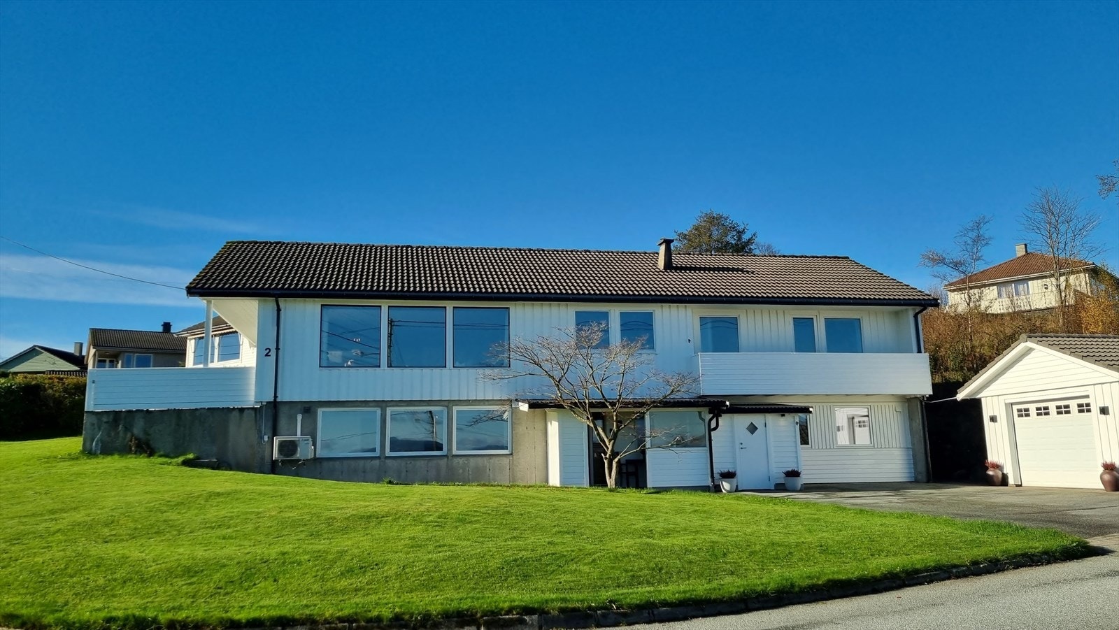 Tomten er pent opparbeidet og kan by på herlige uteområder med gode solforhold - her er det rikelig med boltreplass for hele familien (selgers bilde) Galleribilde