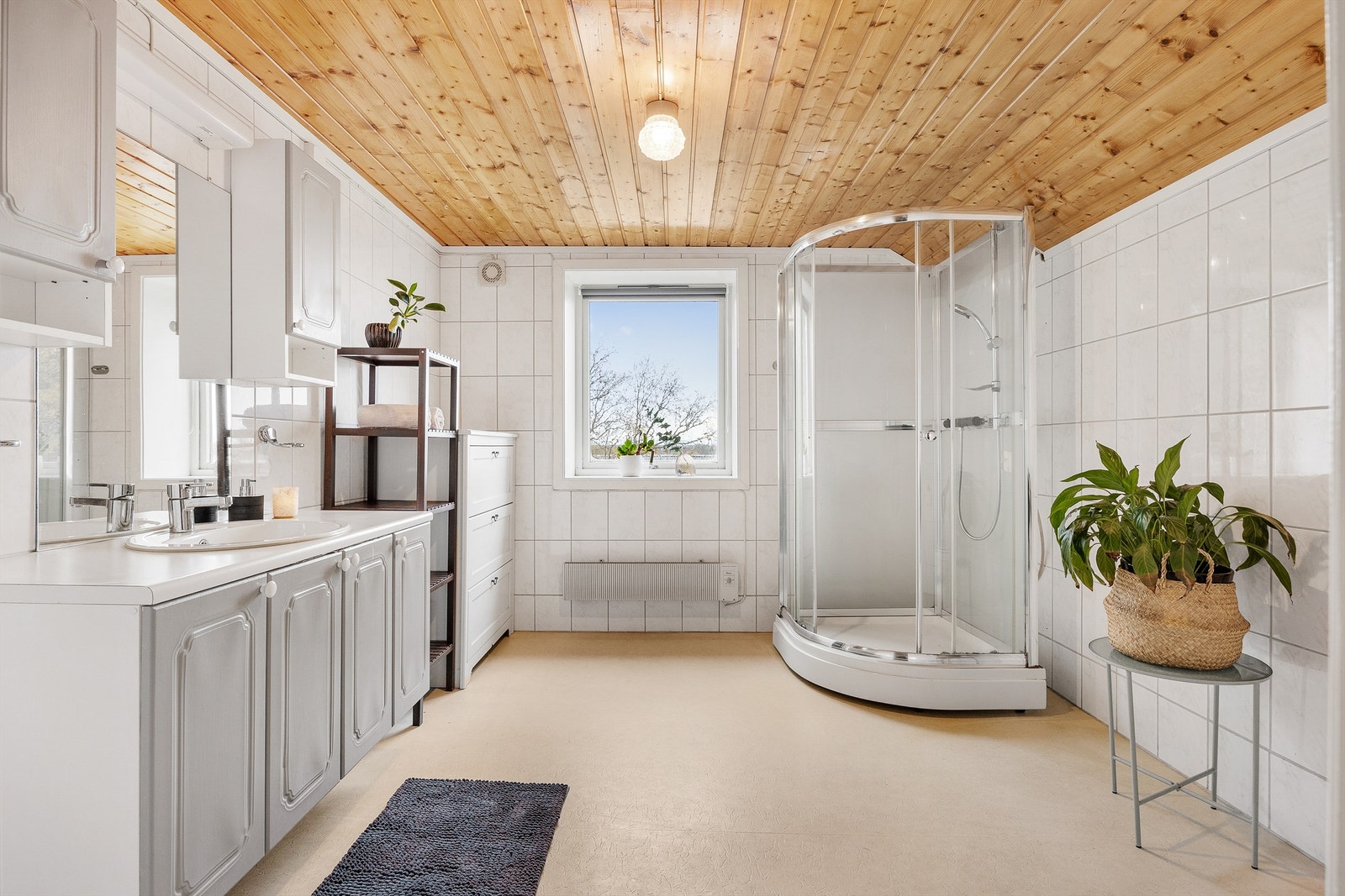 Bad i loftsetasjen med vinylbelegg med oppbrett på vegg og flislagte vegger. Galleribilde