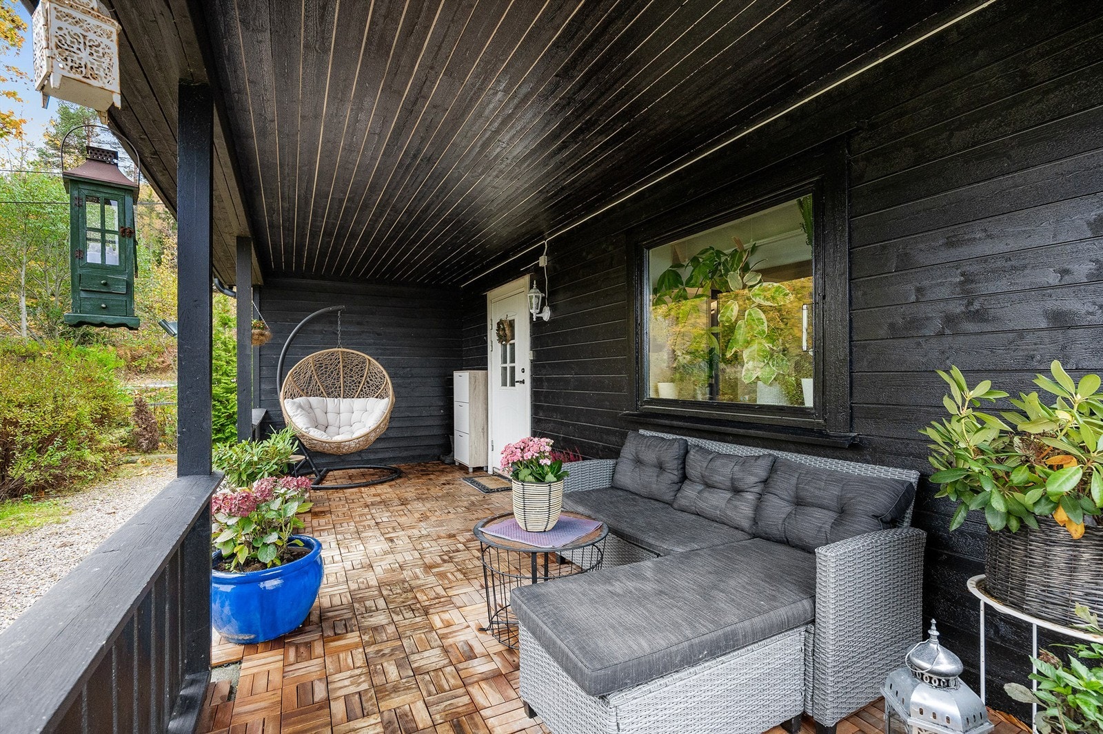 Boligen har et koselig overbygget inngangsparti med rikelig innredningsmuligheter for utemøblement Galleribilde