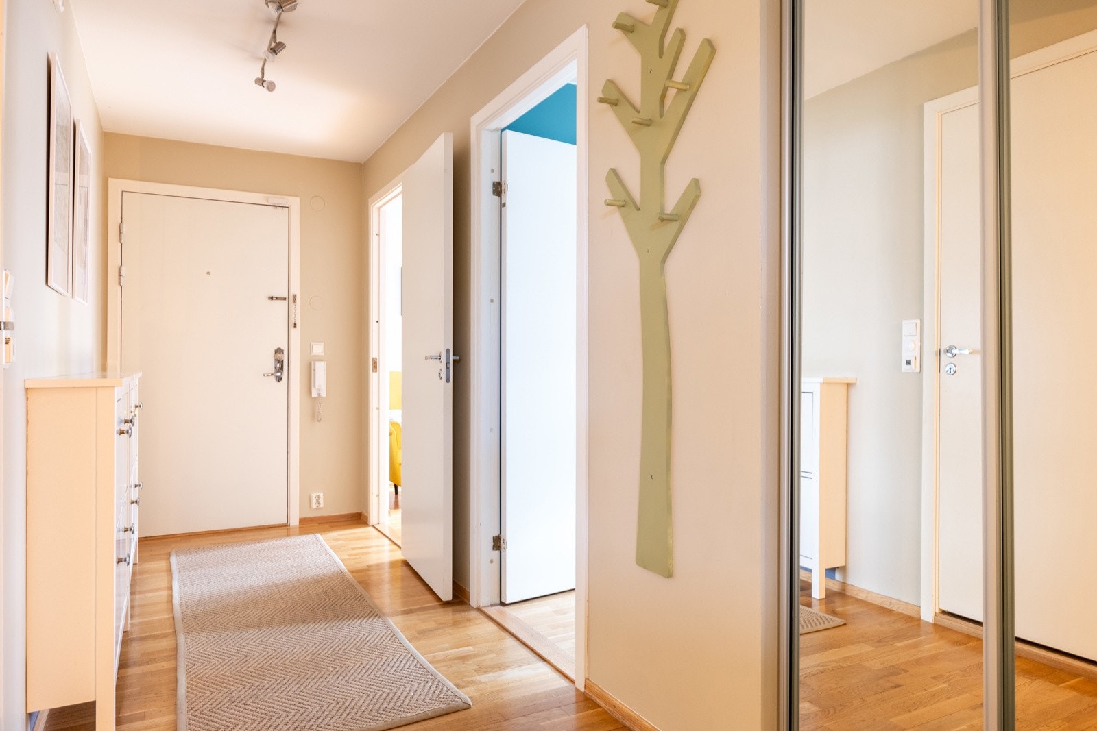 Lys og innbydende entré med skyvedørsgarderobe Galleribilde