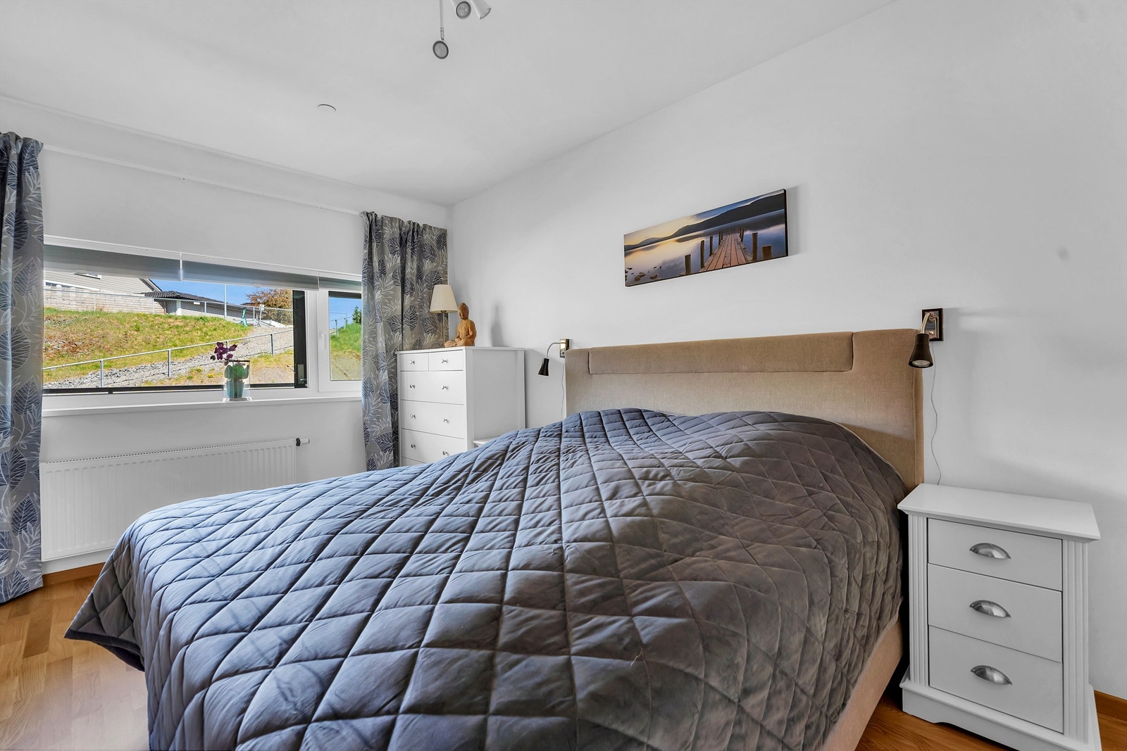 Romslig soverom med god plass til dobbeltseng og nattbord Galleribilde