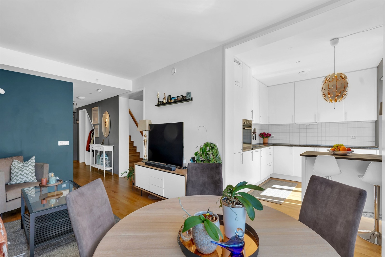 Åpen planløsning med en moderne kjøkkenøy som inkluderer sitteplasser Galleribilde