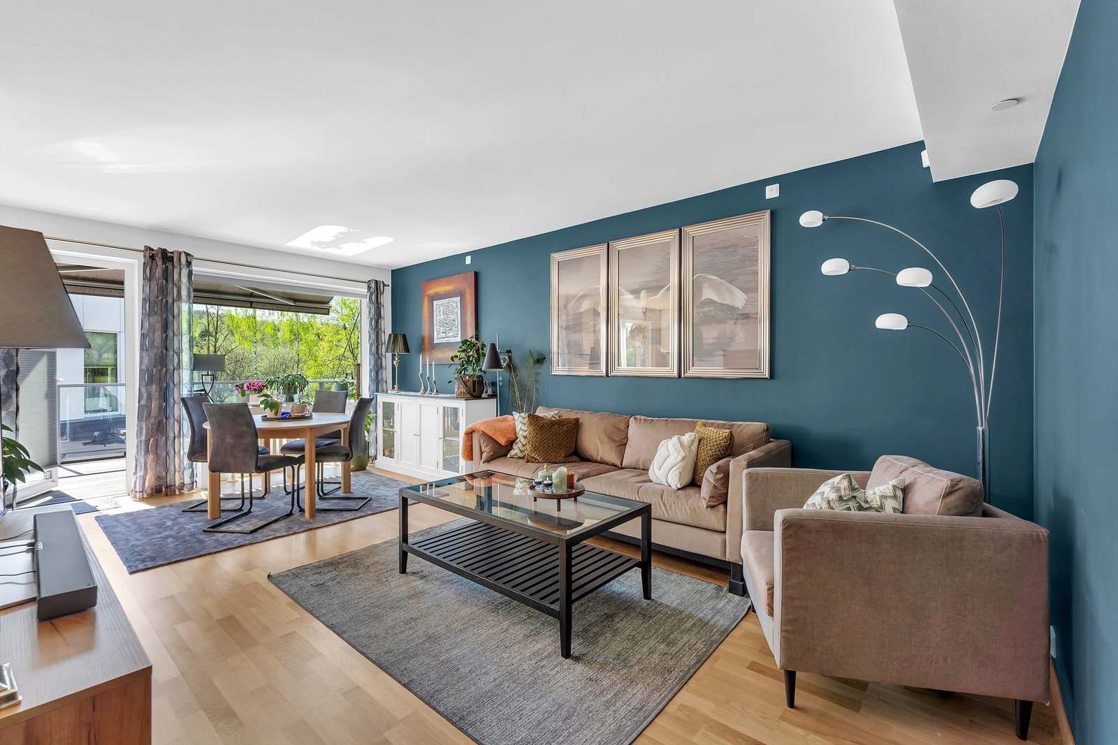 Lys og romslig stue med mye naturlig lysinnslipp fra store vinduer, og utgang til balkong Galleribilde