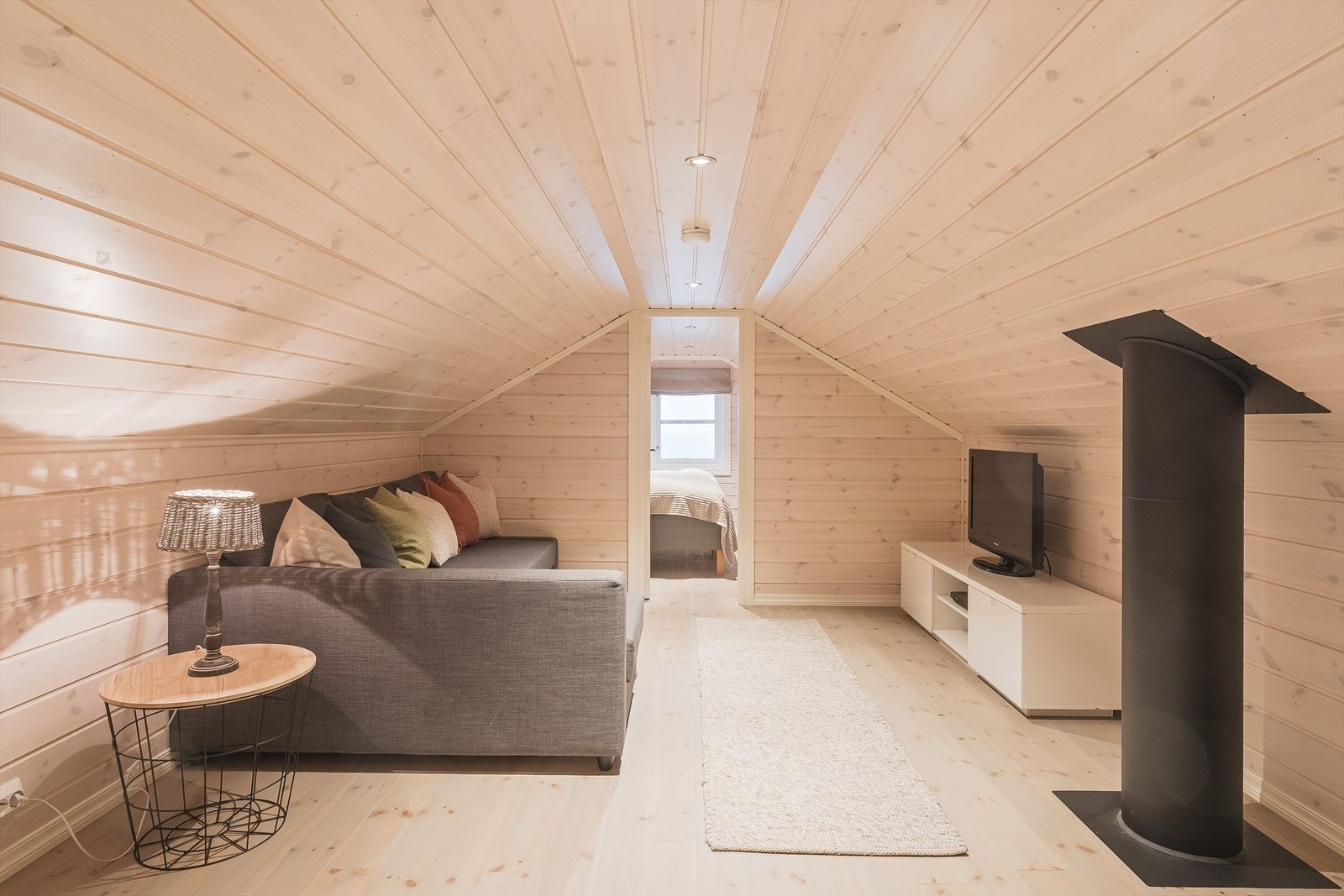 Koselig loftstue med tregulv, overflater med lys liggende panel og downlights i himlingen. Det gjøres oppmerksom på at rommene på hemsen ikke er godkjent for varig opphold. Galleribilde