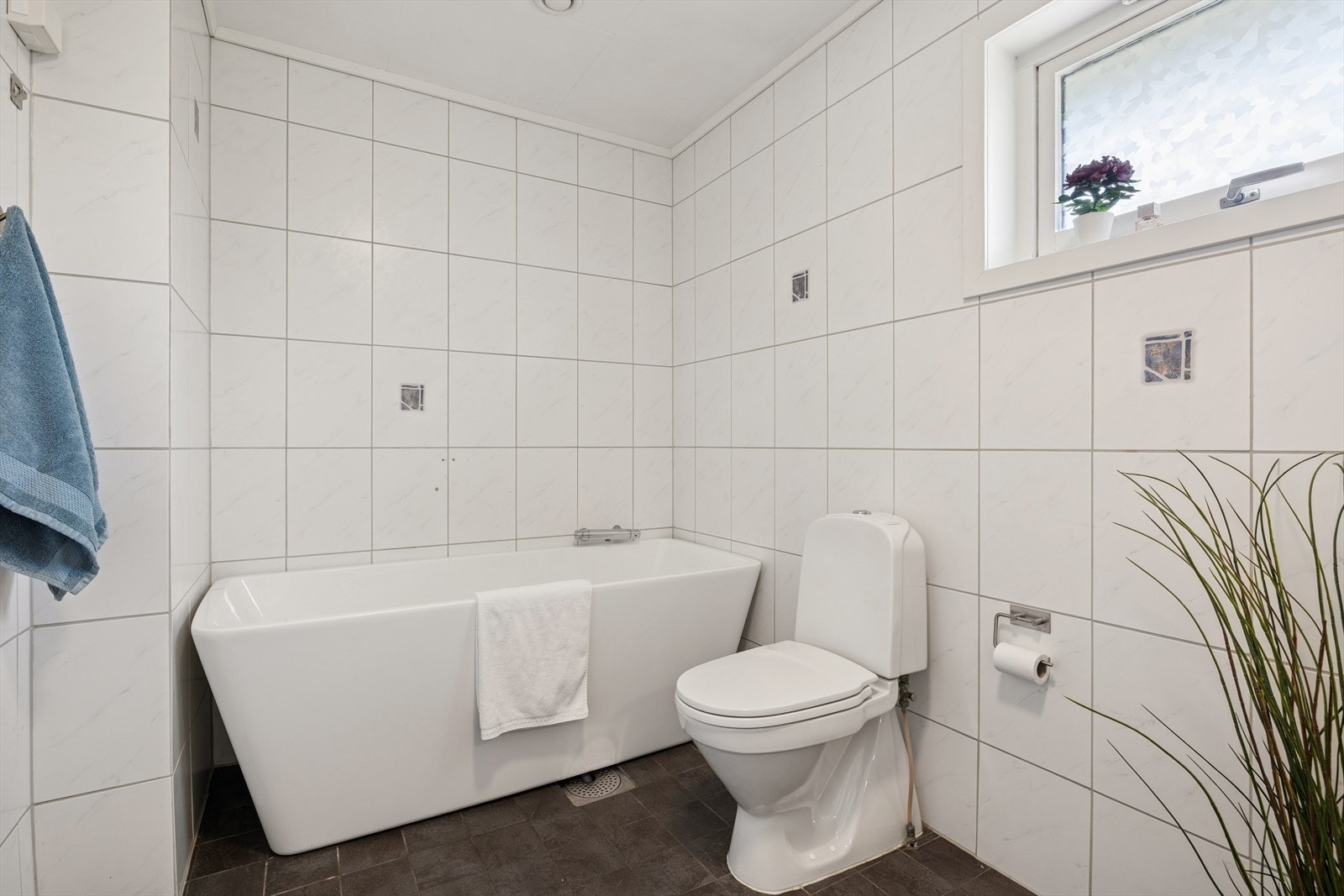 Badet er utstyrt med toalett, badekar, baderomsinnredning med servant og speil. Galleribilde