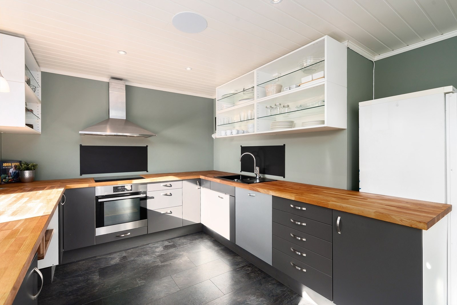 Pent kjøkken med mye skap og benkeplass. Galleribilde