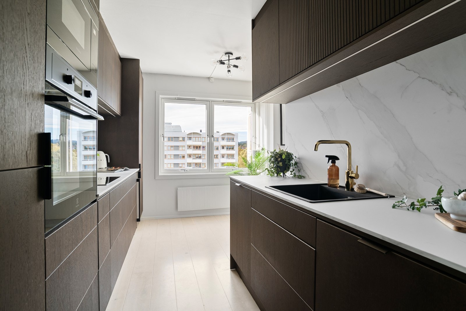 Kjøkkenet har en lekker finnish i mørk eik og lyse benkeplater m/ backsplash Galleribilde