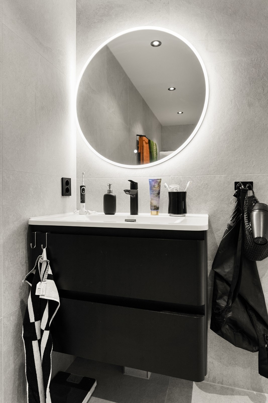 Innredningen består av en servantseksjon med skuffer og et speil med integrert lys. Galleribilde