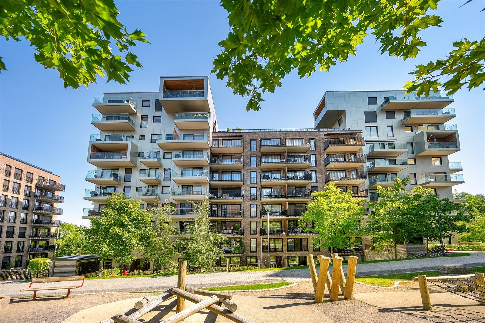 Fellesområdene er pent opparbeidet med gressplen, lekeapparater og sittegrupper Galleribilde