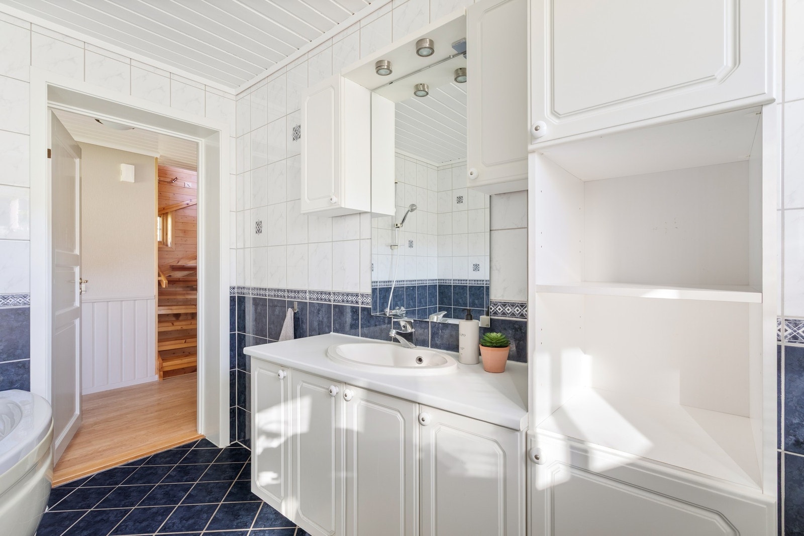 Badet har god skap plass til hygiene møblementer og servant med underskap og speil Galleribilde