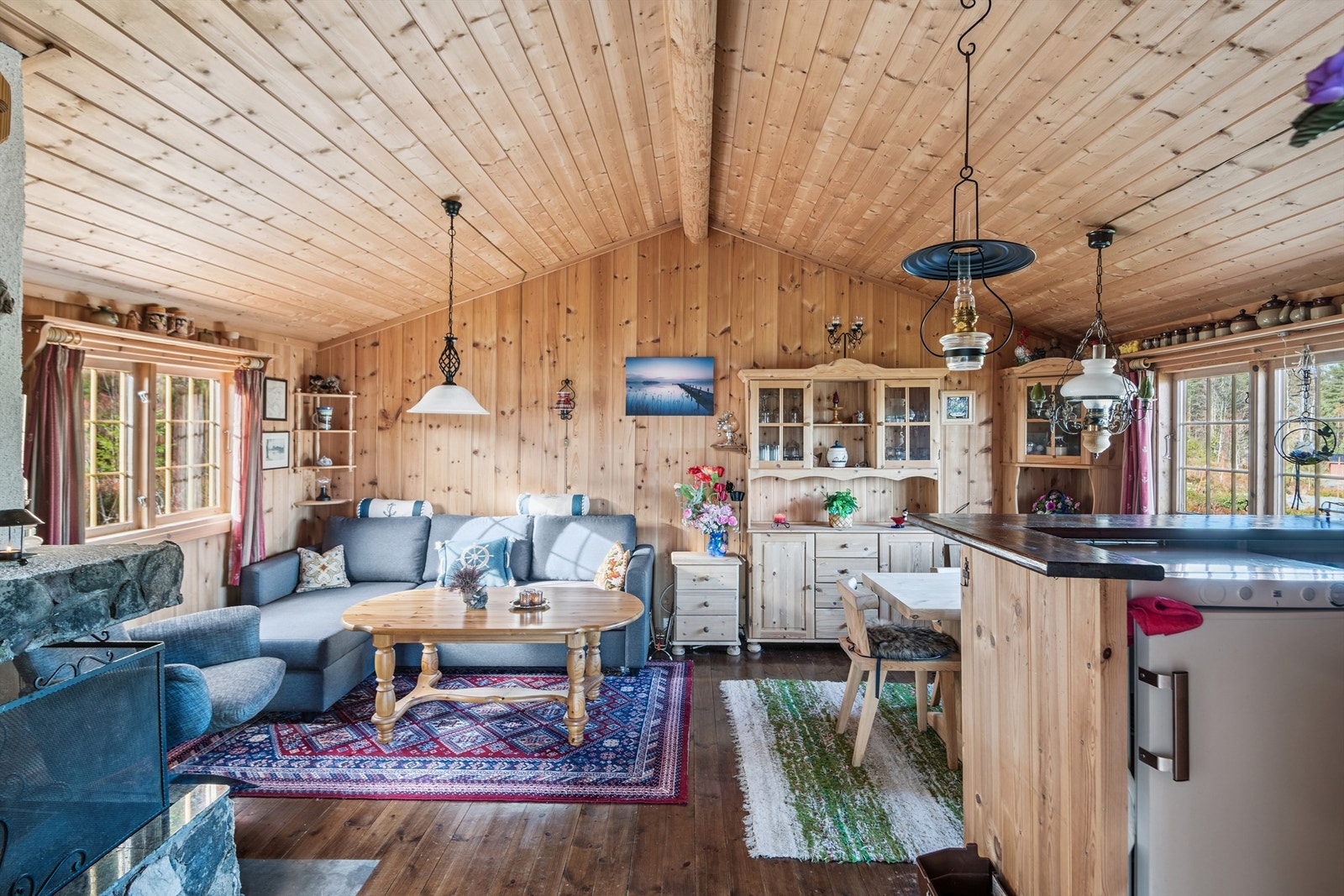 Gjennomgående trepanel på vegger og skråhimling skaper en klassisk og koselig hyttestemning. Galleribilde