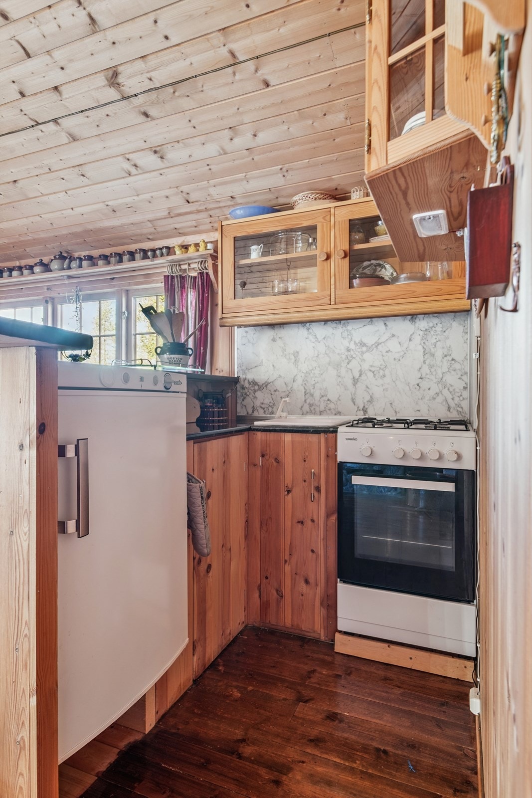 Kjøkkenkroken har en plassbygget innredning med plass for gasskomfyr og gasskjøleskap. Galleribilde