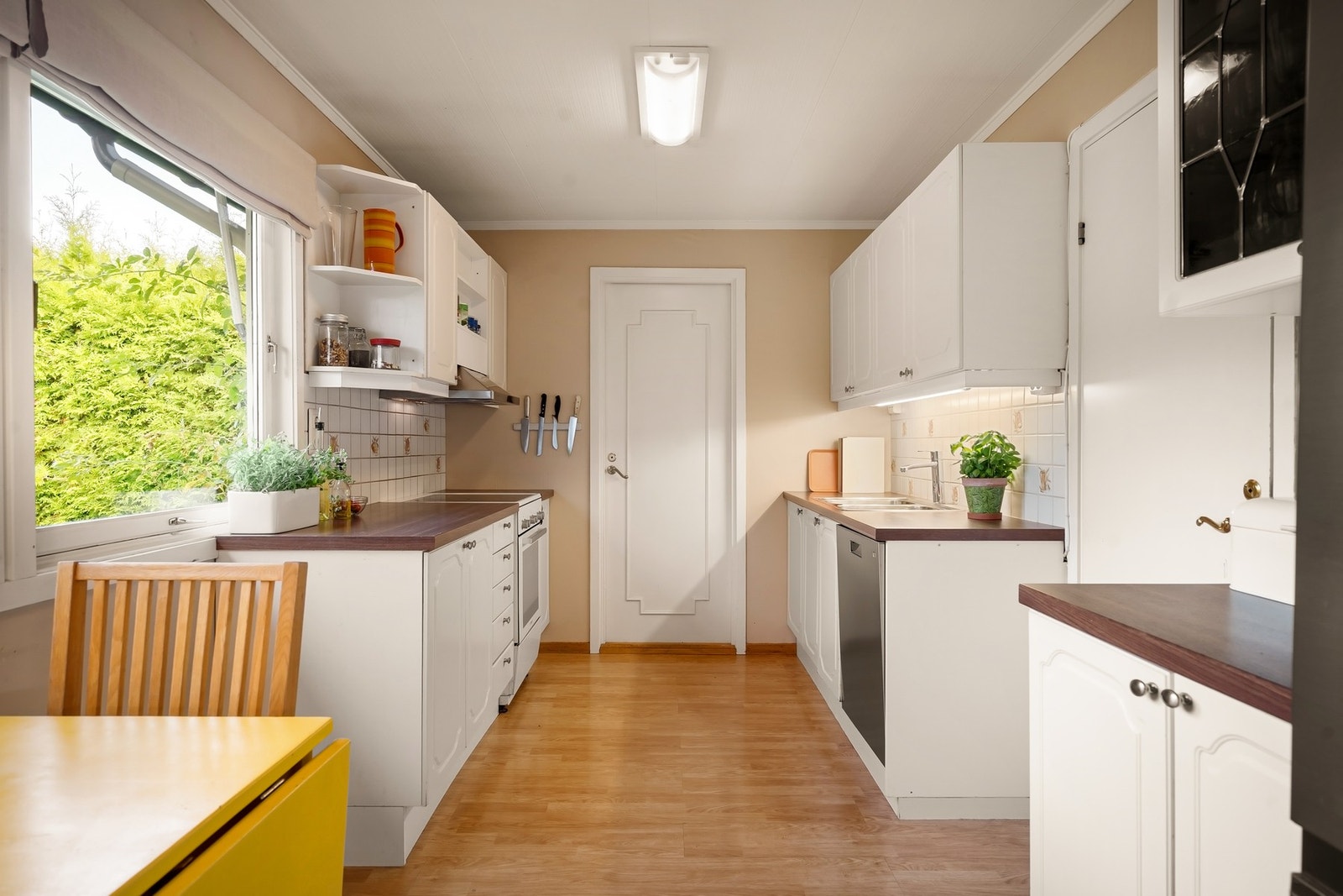 Kjøkken med god arbeidsplass. Innredning med glatte fronter, laminat benkeplate og fliser bak benkeplater Galleribilde