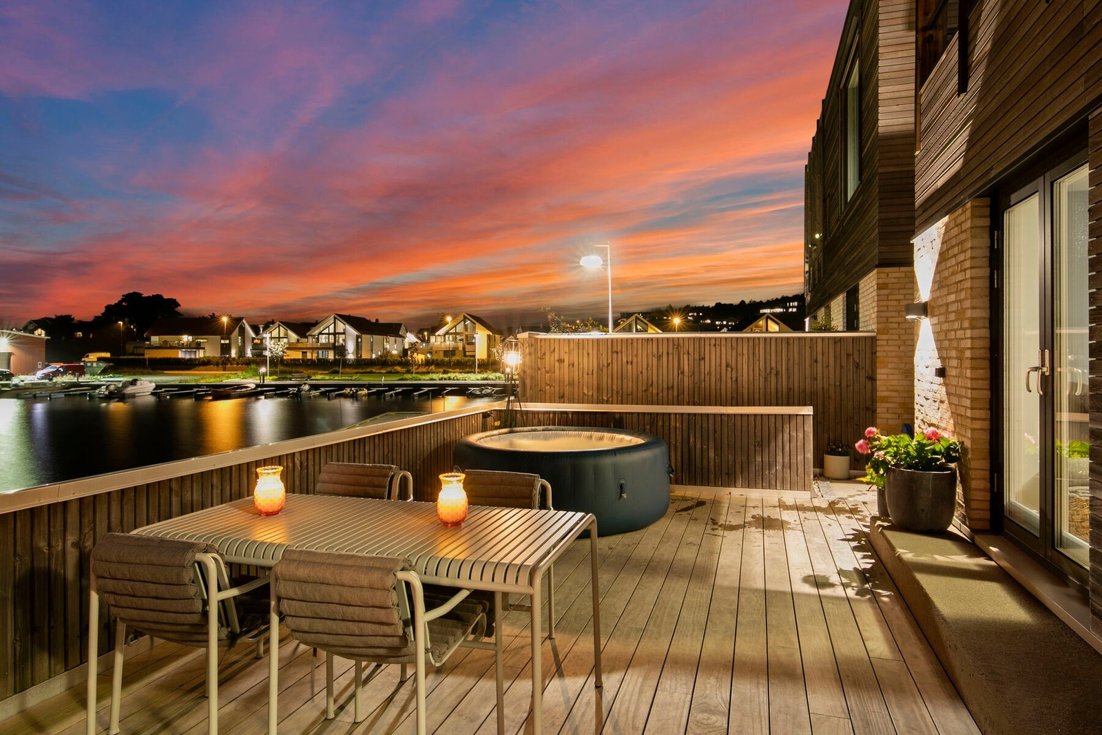 Stor terrasse med plass til spisegruppe, lounge og massasjebad - et sted for hygge, ro og utsikt mot sjø og kveldshimmel. Galleribilde