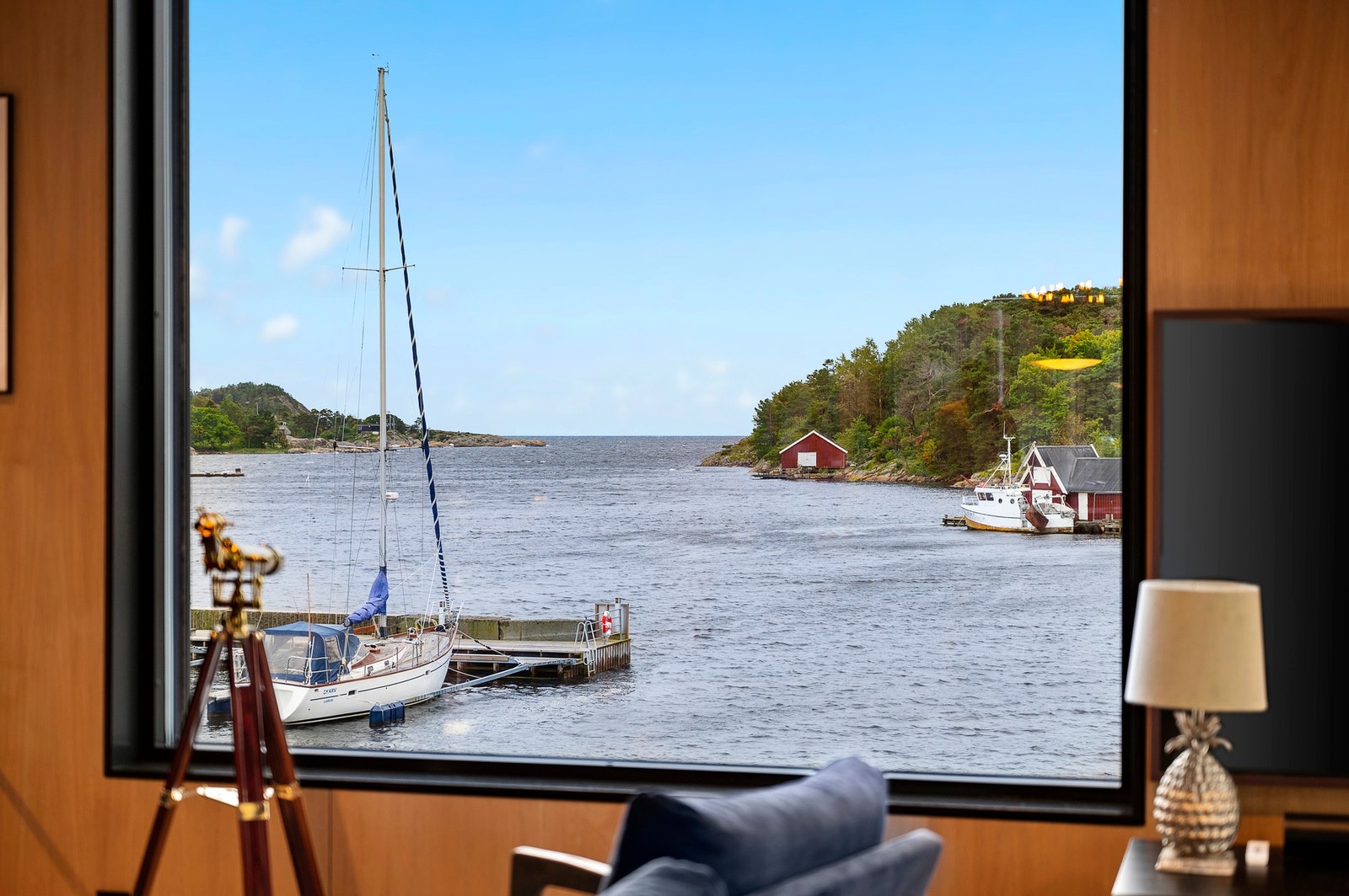 Storslått utsikt mot fjorden - her får du følelsen av å bo midt i kystlandskapet. Store vindusflater slipper inn lyset og trekker sjøen helt inn i stuen. Galleribilde