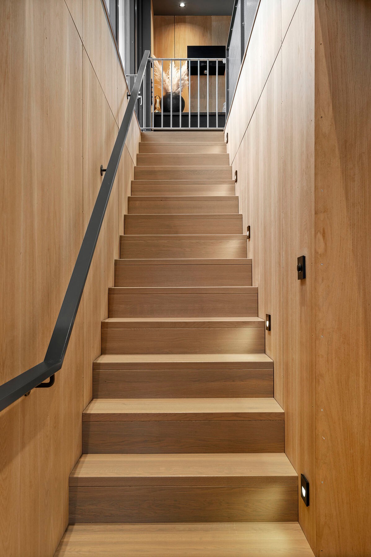 Eksklusiv trappeløsning i heltre med integrert belysning - et arkitektonisk blikkfang som binder etasjene sømløst sammen. Galleribilde