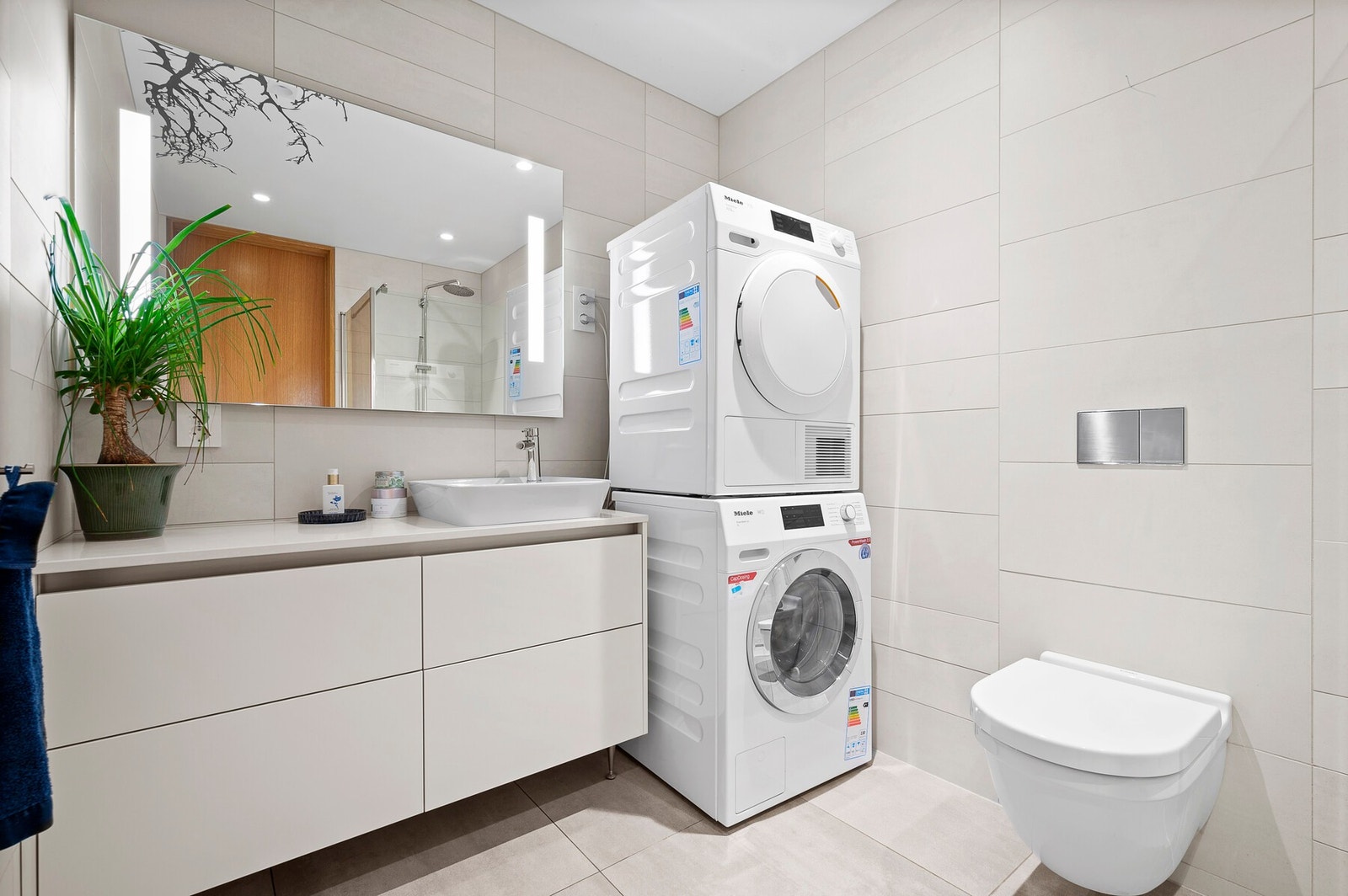 Hovedbadet kombinerer stil og funksjon med moderne innredning, god oppbevaringsplass og integrert vaskesone med kvalitetsapparater. Galleribilde