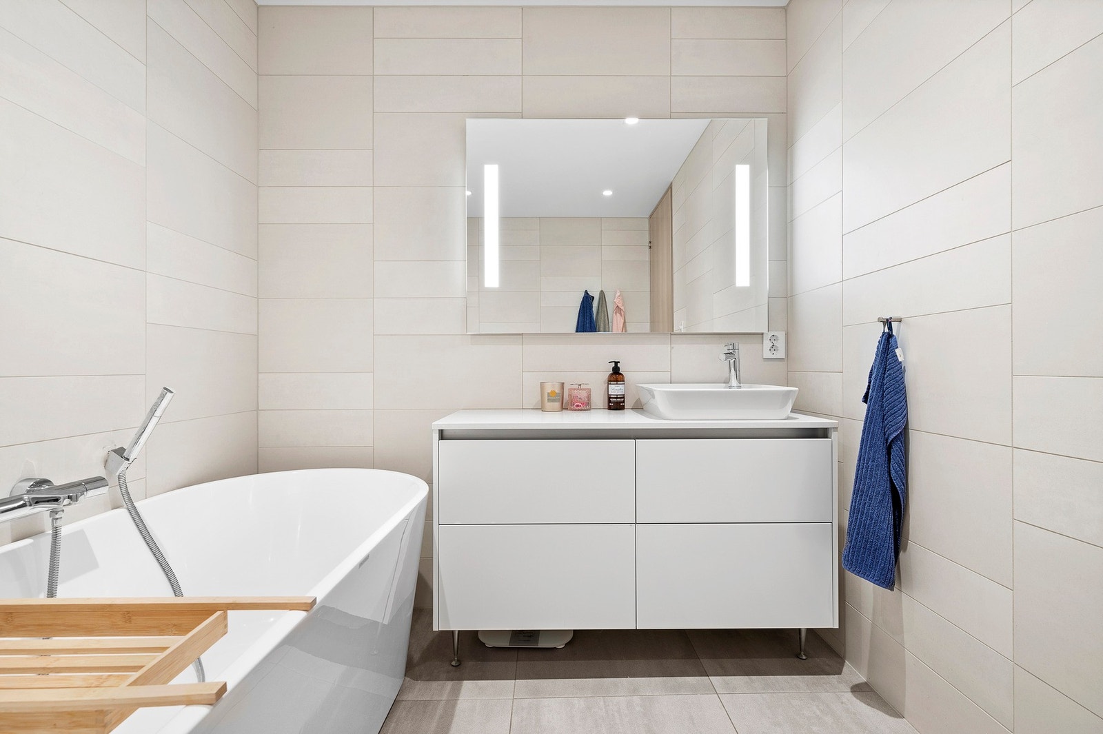 Lekkert baderom med frittstående badekar, moderne servantinnredning og smakfulle detaljer. Galleribilde