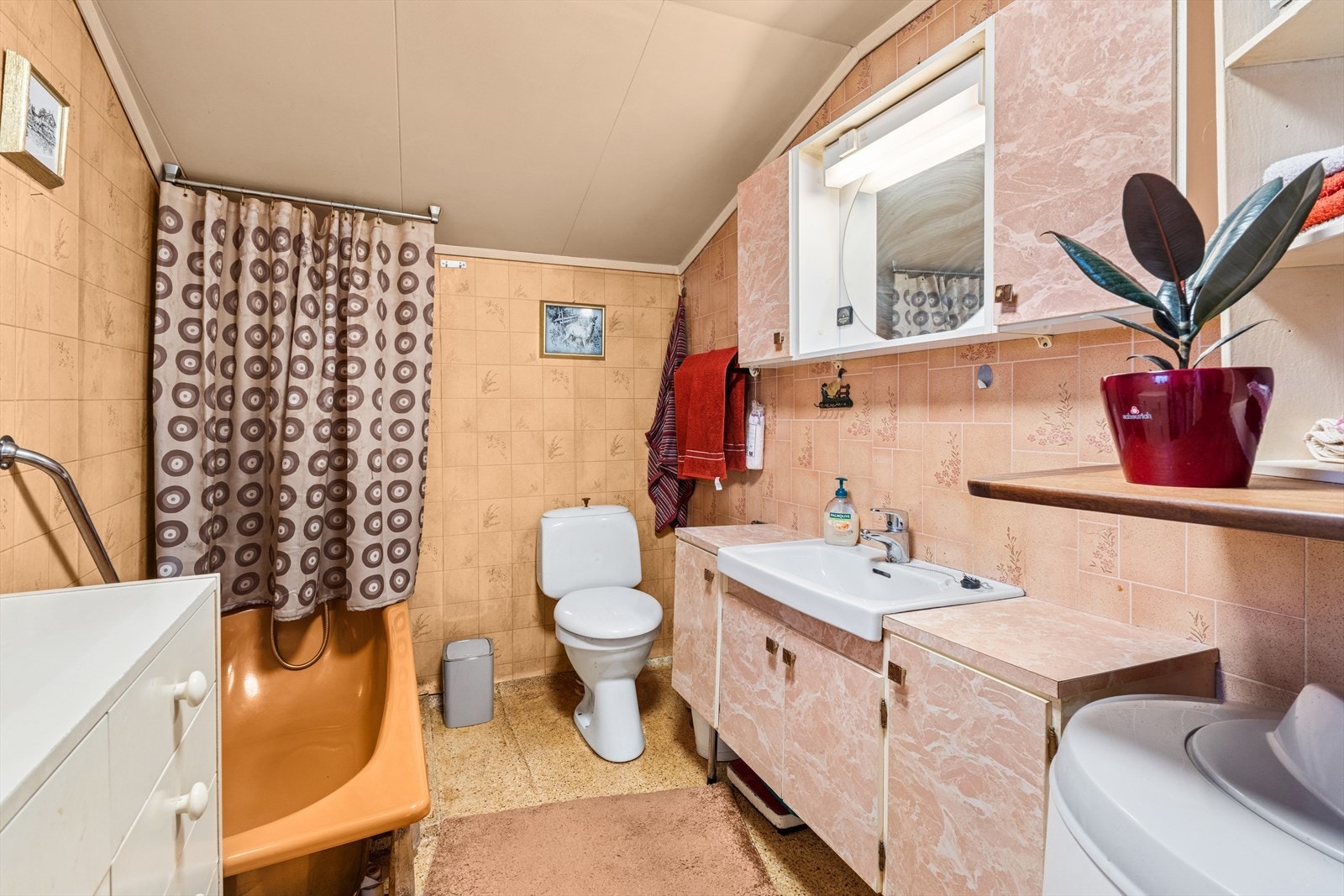 På badet er det toalett, baderomsinnredning og badekar med dusjnisje Galleribilde