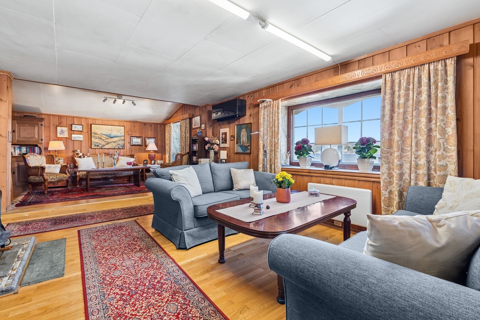 Romslig todelt stue med god plass til både sittegruppe og spisestue Galleribilde