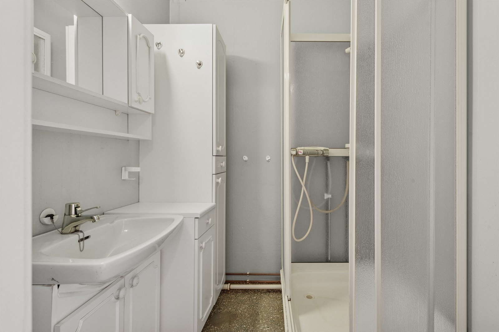 Eldre bad med dusjkabinett og baderomsinnredning. Det er separat toalletrom og vaskerom. Galleribilde