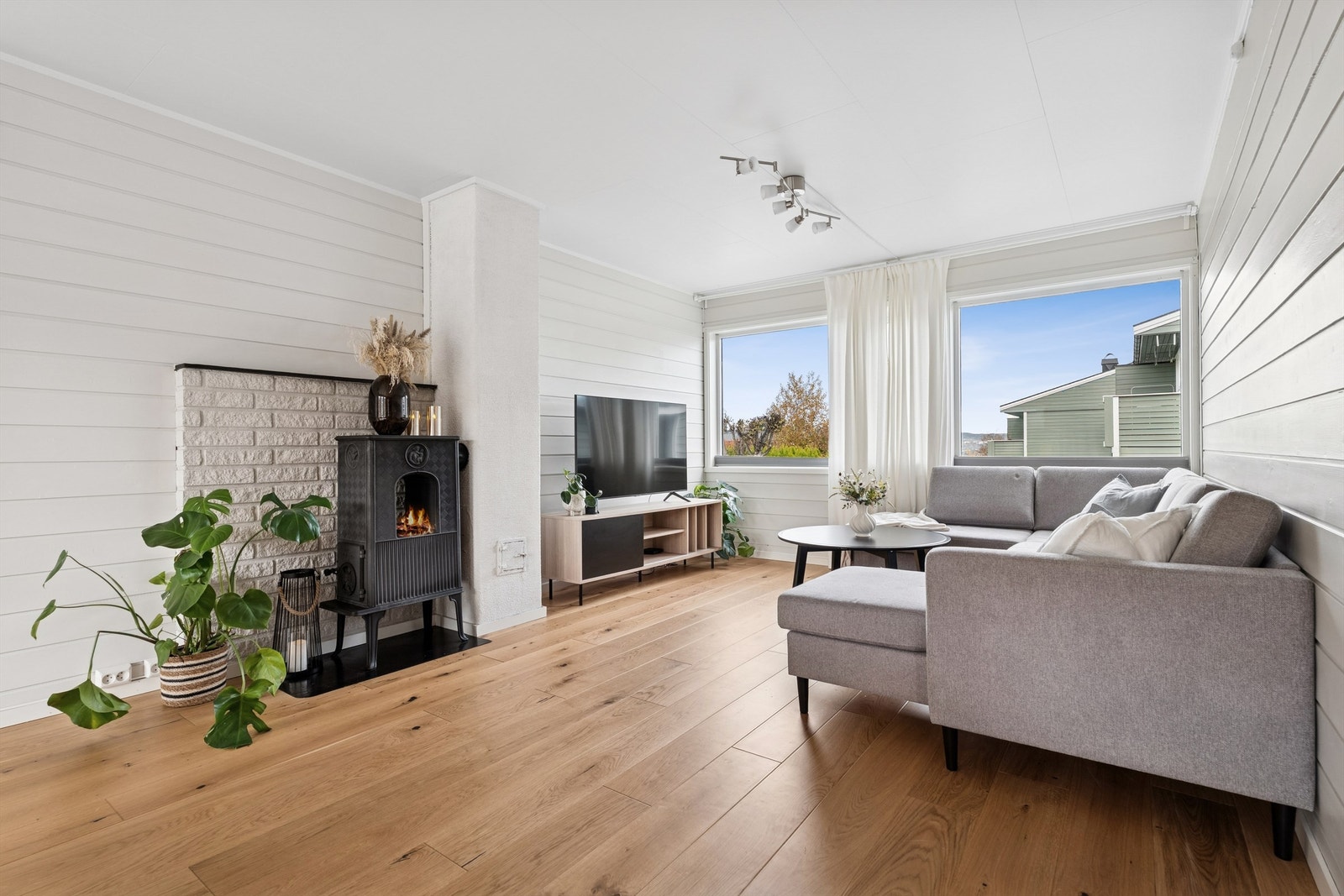 God oppvarming i stuen med vedovn som gir både stemning og varme, supplert av en luft-til-luft varmepumpe fra 2020. Galleribilde