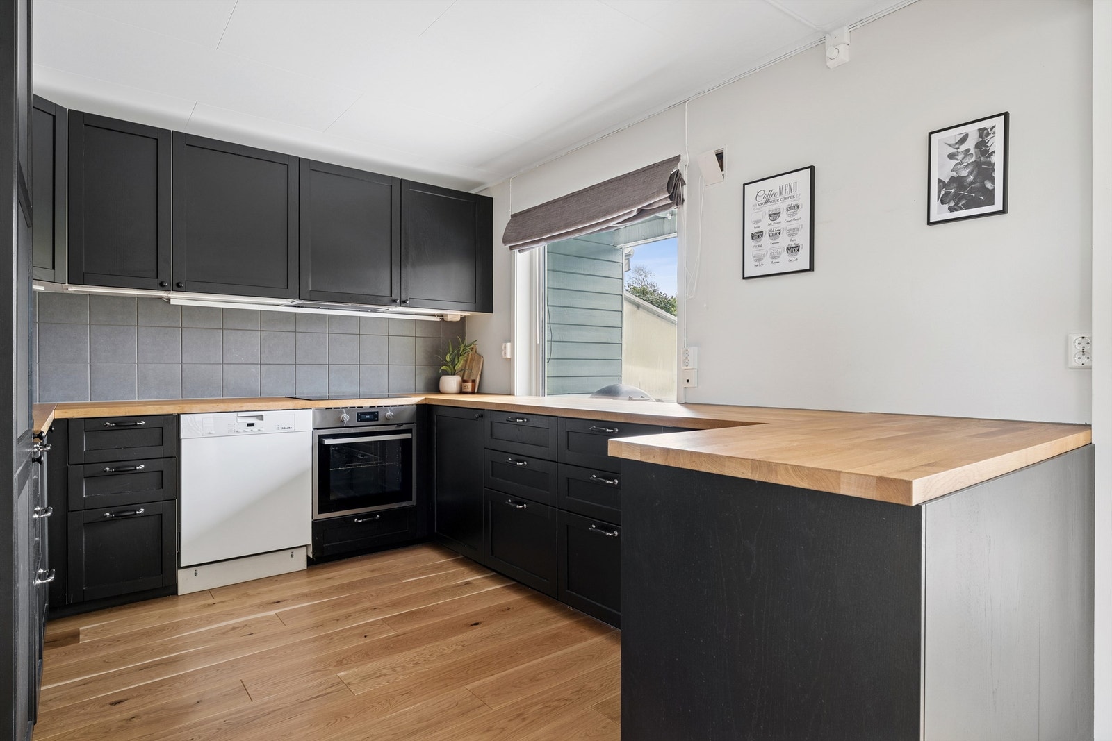 Kjøkkeninnredningen har profilerte fronter, laminert benkeplate og godt med skap- og benkeplass. Galleribilde