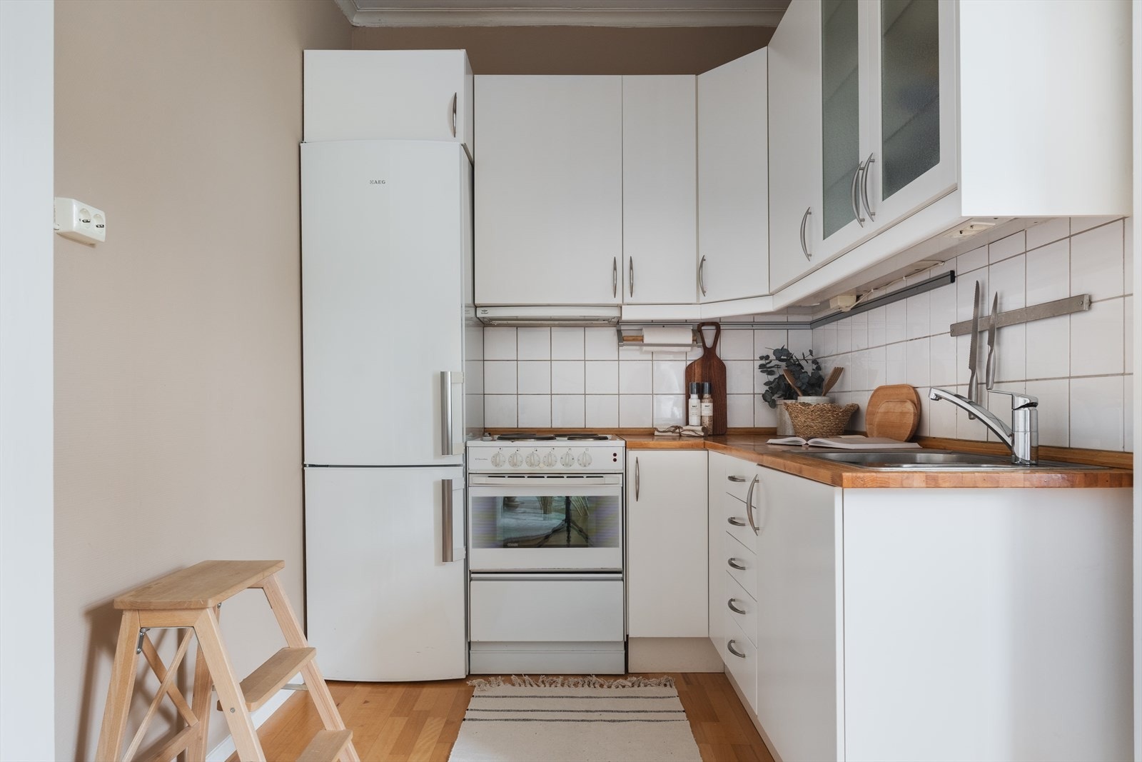 Kjøkkenet er utstyrt med benkeplate i tre med nedfelt oppvaskkum, avtrekksvifte, frittstående komfyr og kjøleskap. Galleribilde