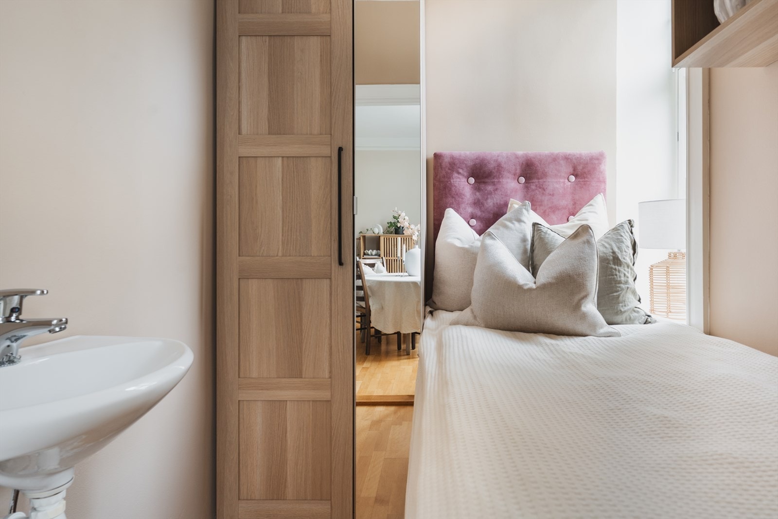 Praktisk soverom med servant, plassbygget seng og garderobeskap. Galleribilde