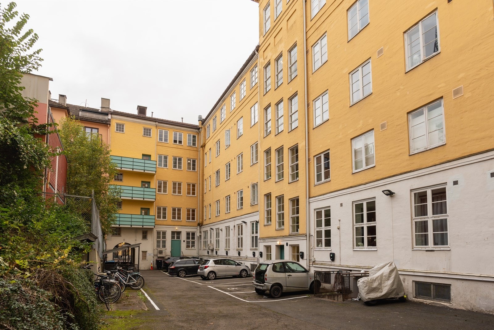 Sykkelparkering og parkeringsplasser til leie etter liste i bakgård - både langtid og korttidsparkering. Galleribilde