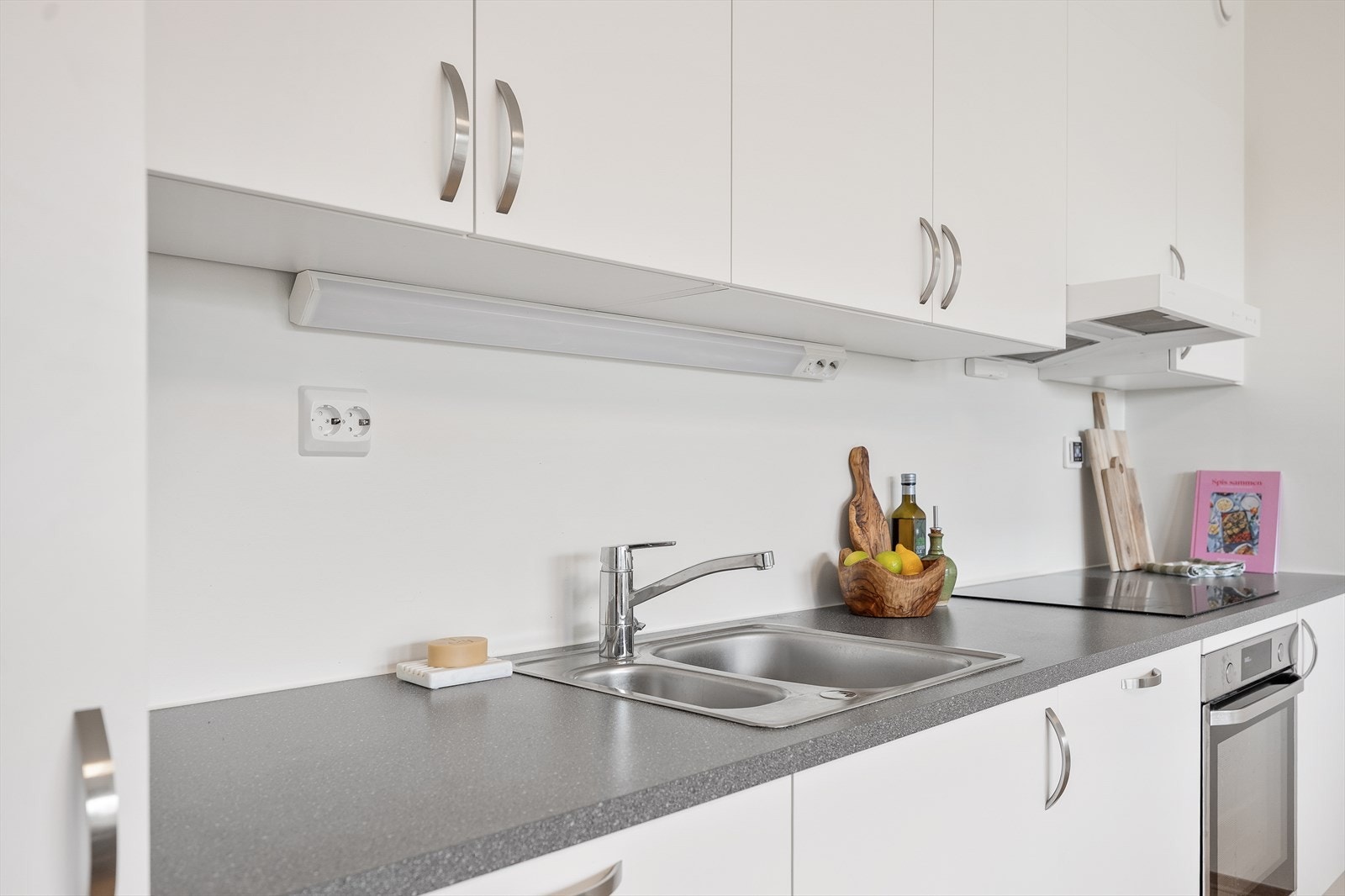 Kjøkkenet har integrerte hvitevarer som koketopp, stekeovn, oppvaskmaskin og kombinert kjøl/fryseskap. Galleribilde