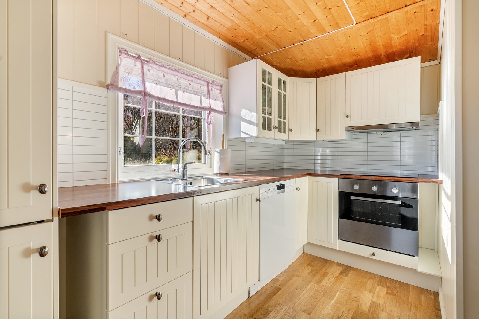 Hvit kjøkken med profilerte fronter og laminat benkeplate. Innredningen har integrert platetopp, stekeovn, oppvaskmaskin og
kjøleskap m/frys. Galleribilde