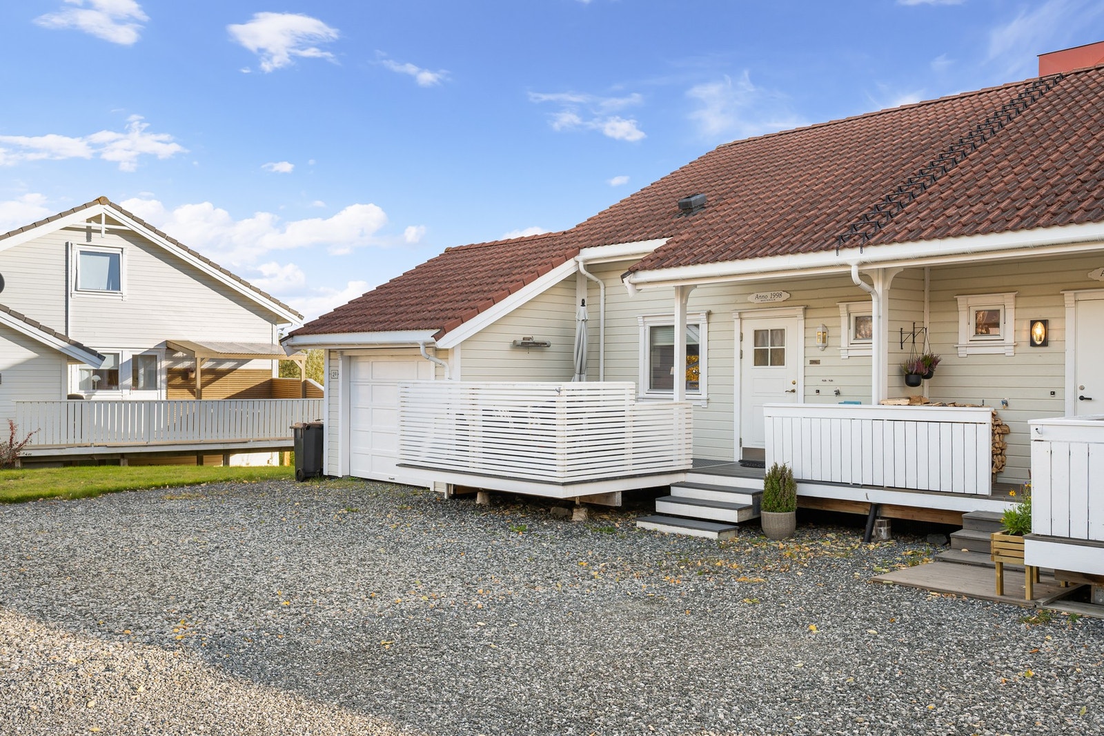 Garasje og gruset gårdsplass med plass til parkering for flere biler Galleribilde