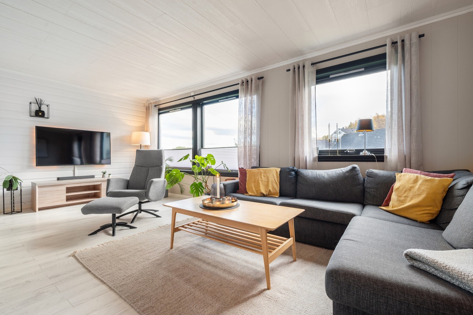 Lys og romslig stue med store vindusflater som gir rikelig med lys Galleribilde