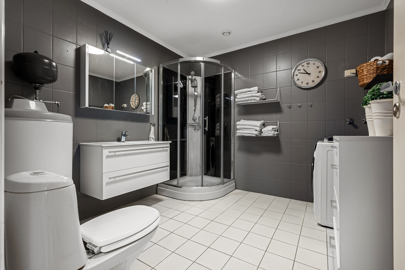 Romslig bad innredet med servant, speilskap på vegg og dusjkabinett Galleribilde