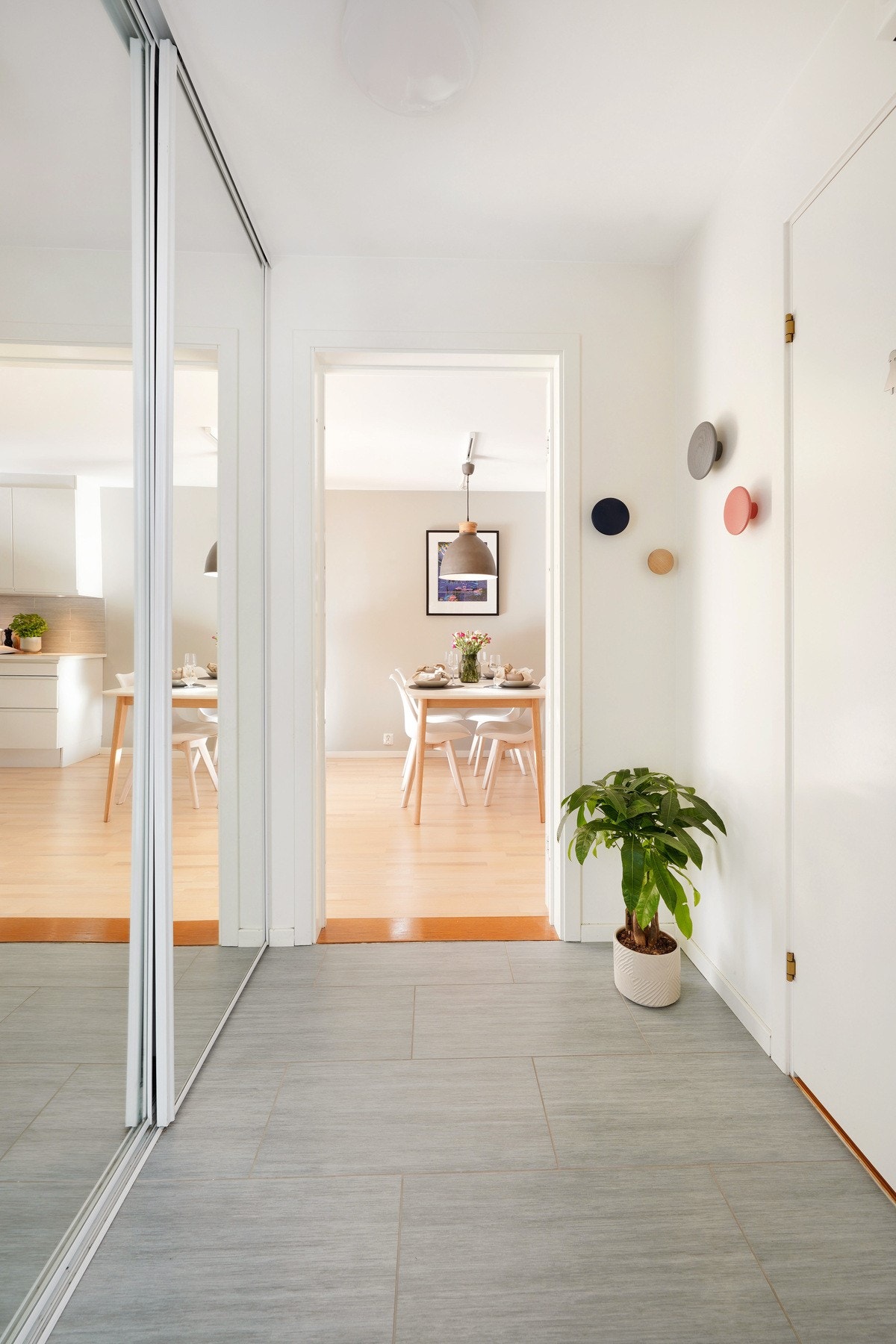 Romslig gang med fliser samt speilsatt skyvedørsgarderobe Galleribilde