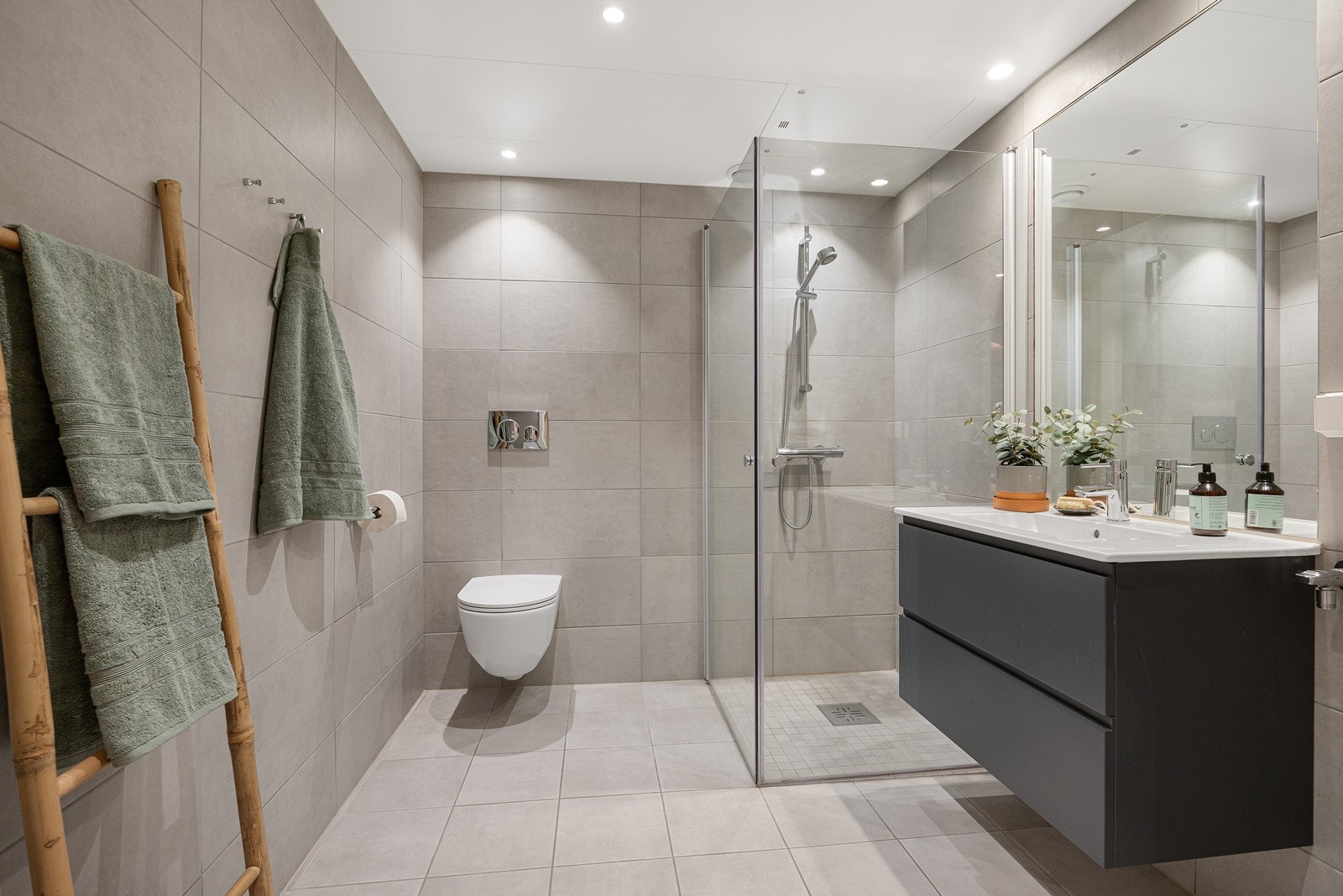 Badet er stilrent og har lysegrå fliser på både gulv og vegger. Galleribilde