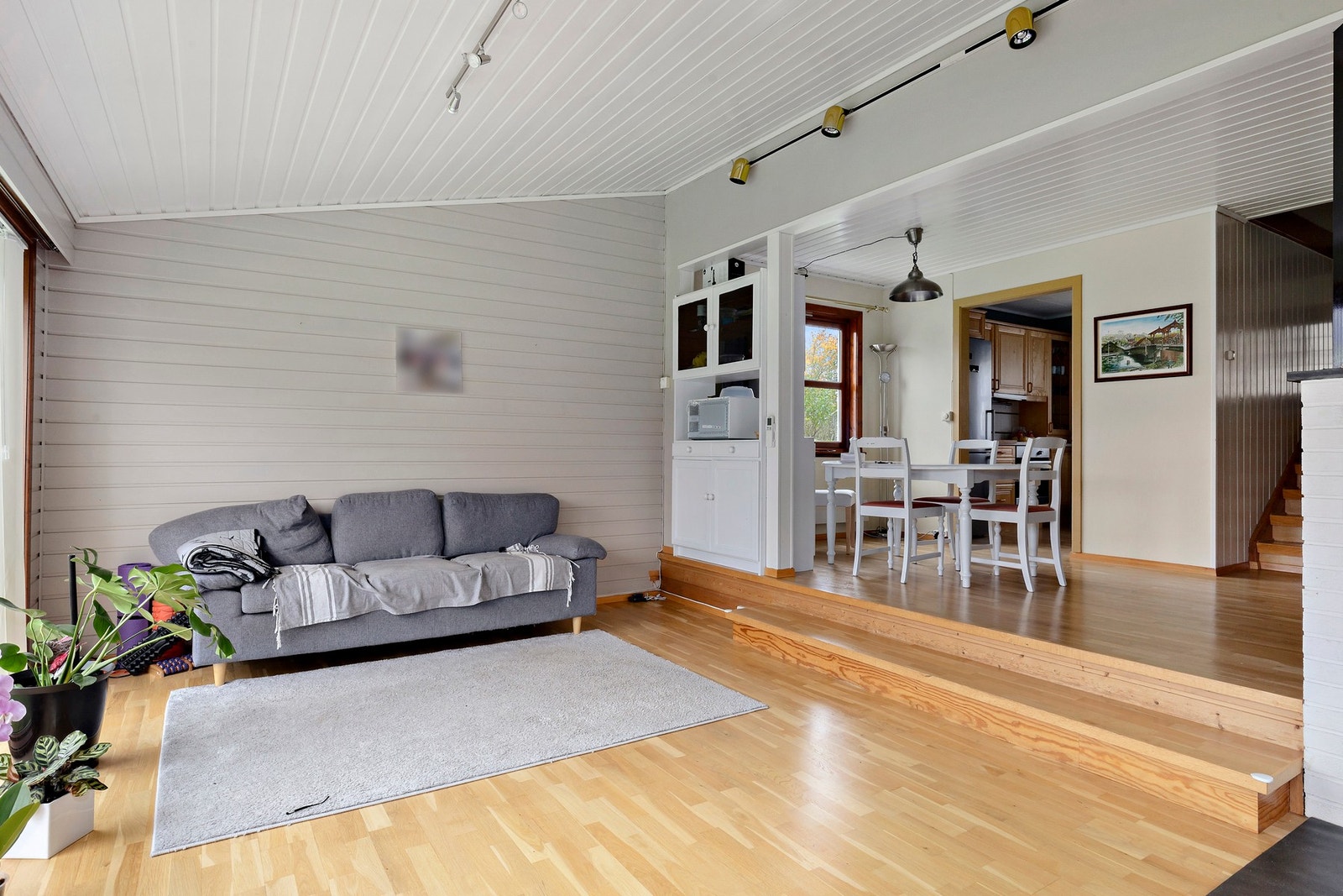 Stuen har parkett på gulv og malte panel og overflater på vegger. Galleribilde