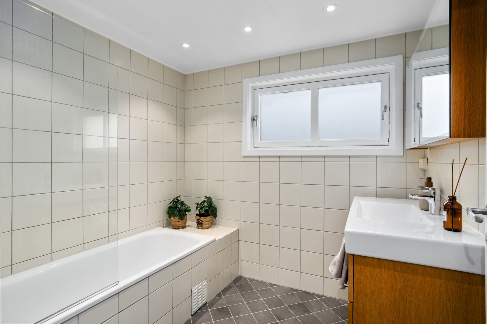 Flislagt bad/vaskerom med badekar og gulvvarme. Galleribilde