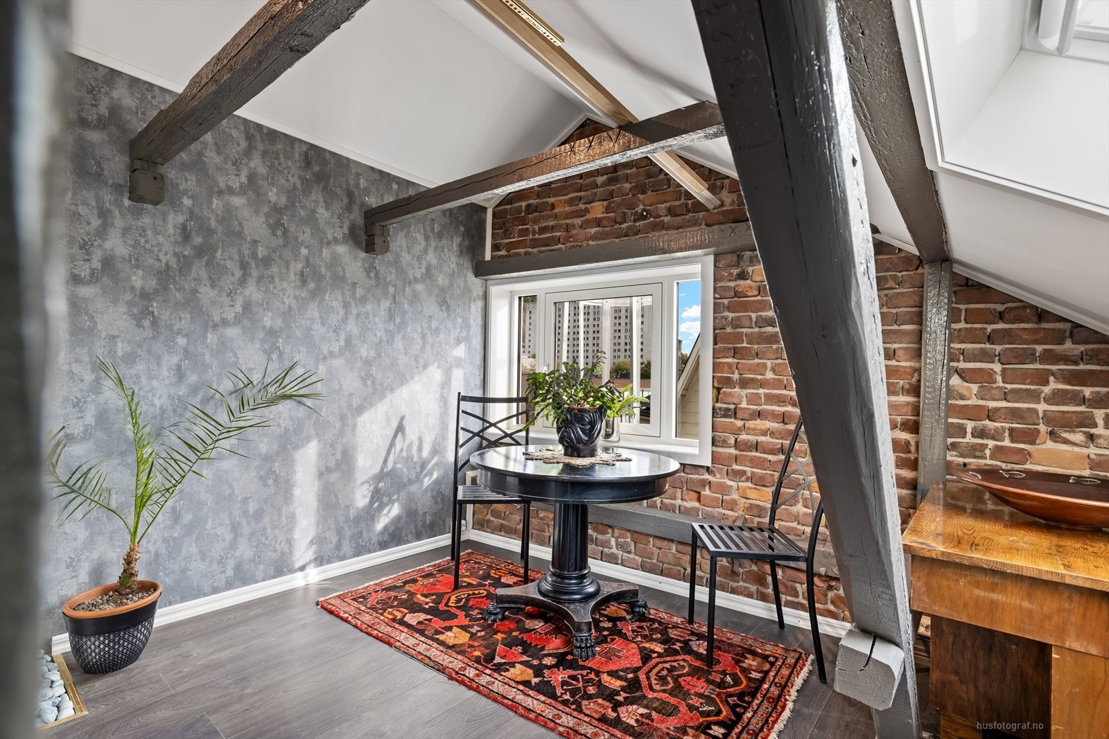 Skråvegger med synlige bjelker og innslag av den originale murveggen. Galleribilde