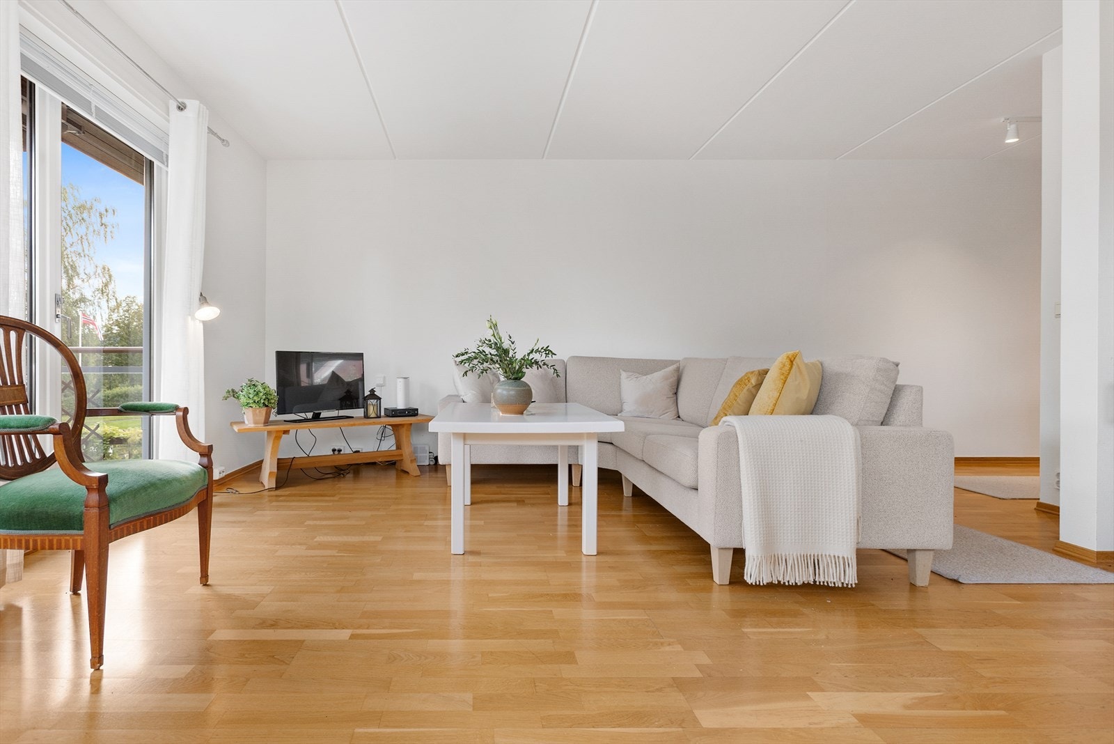 Stue har store vinduer som slipper rikelig med naturlig lys og med utgang til balkong/terrasse. Galleribilde